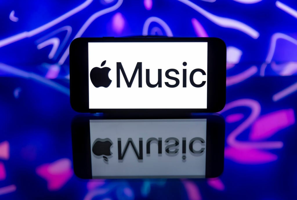 Apple Music logo on phone screen against blue background