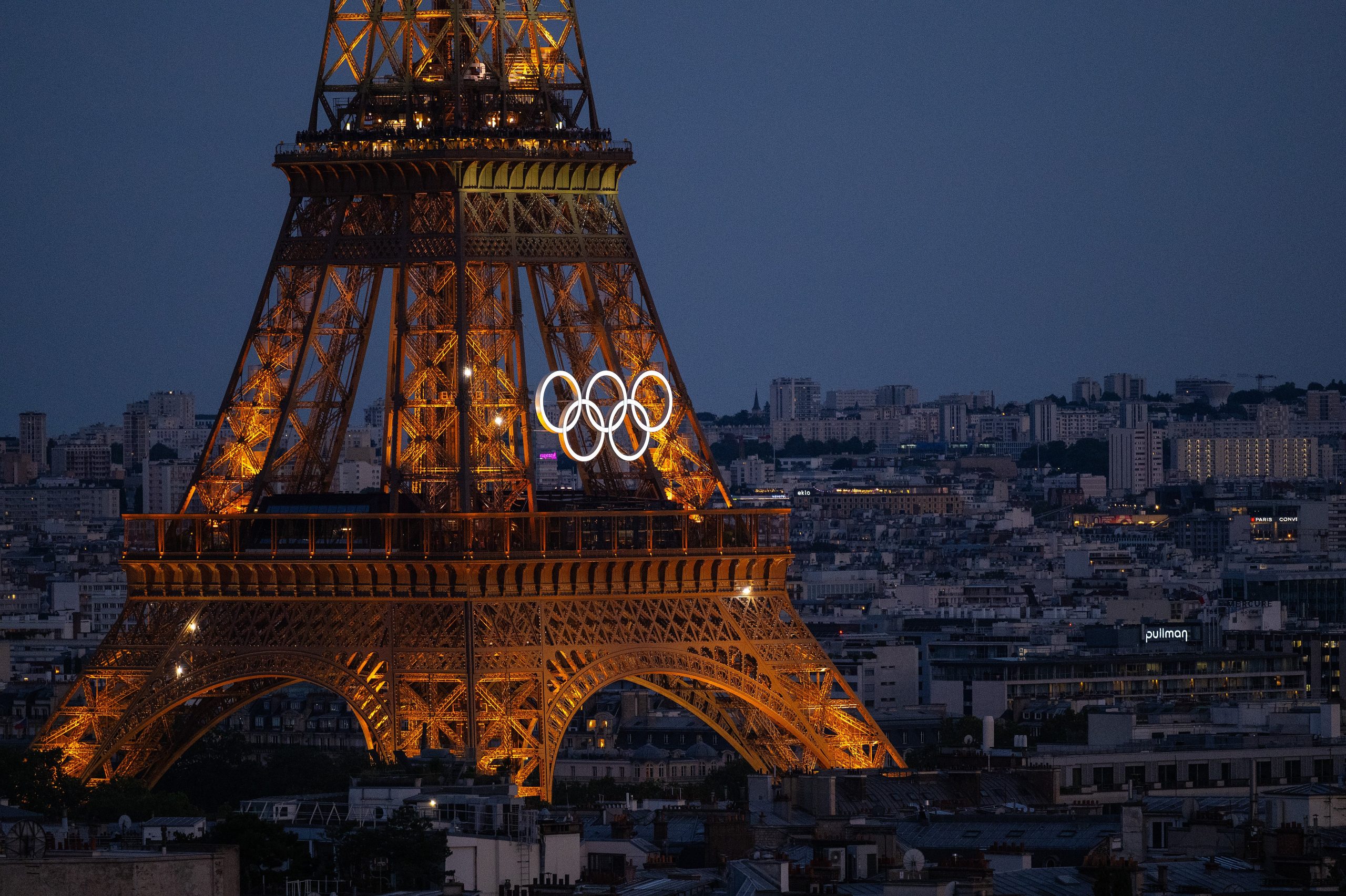 eiffel tower lit up at night with olympic rings on it