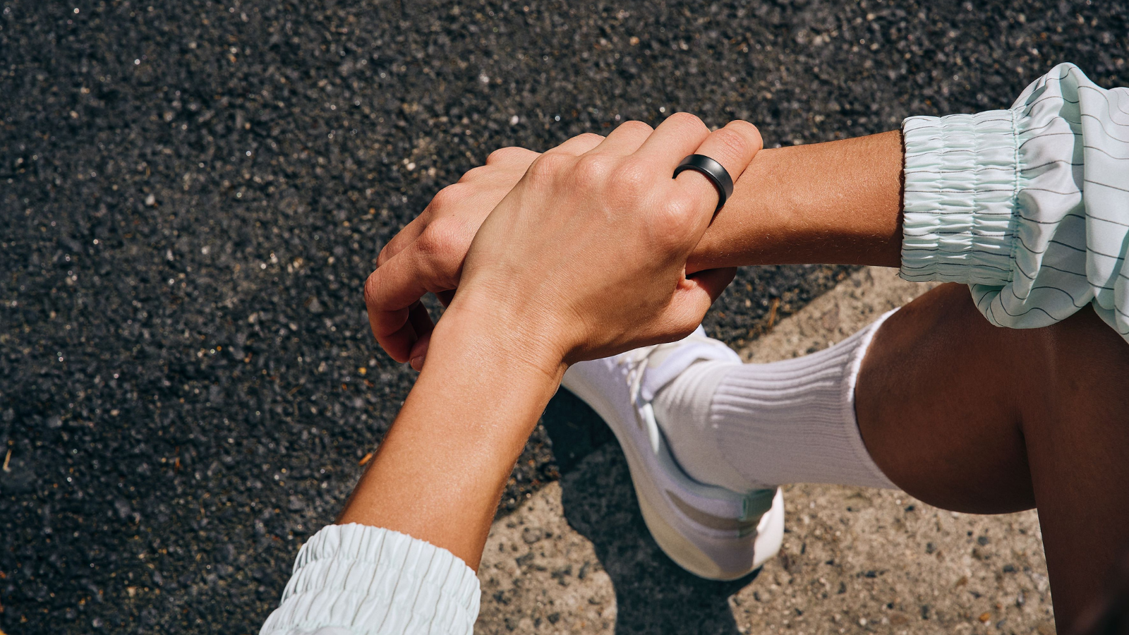 a close-up of a samsung galaxy ring on the finger of a resting runner