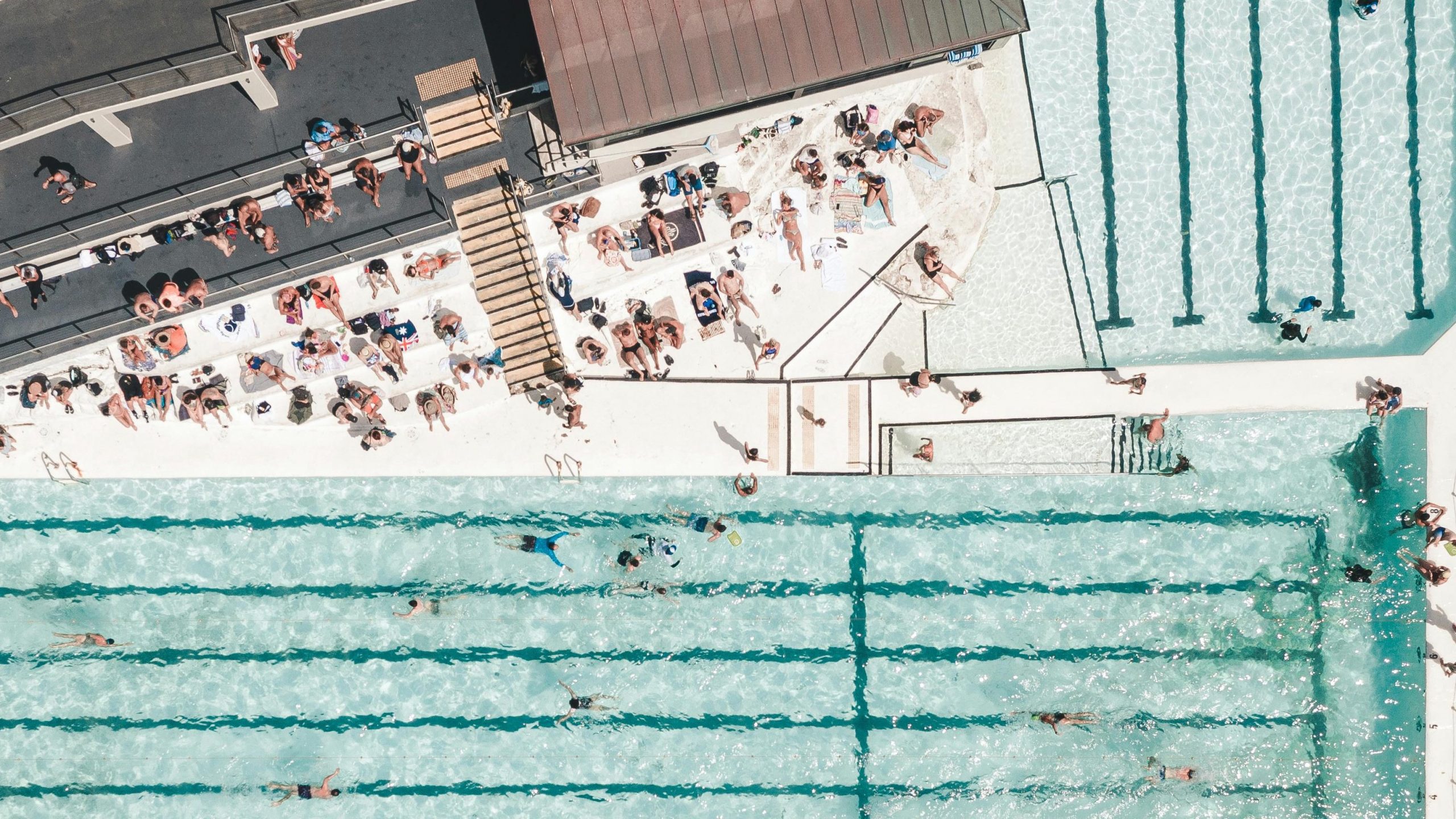 aerial drone photograph of crowded public swimming pool