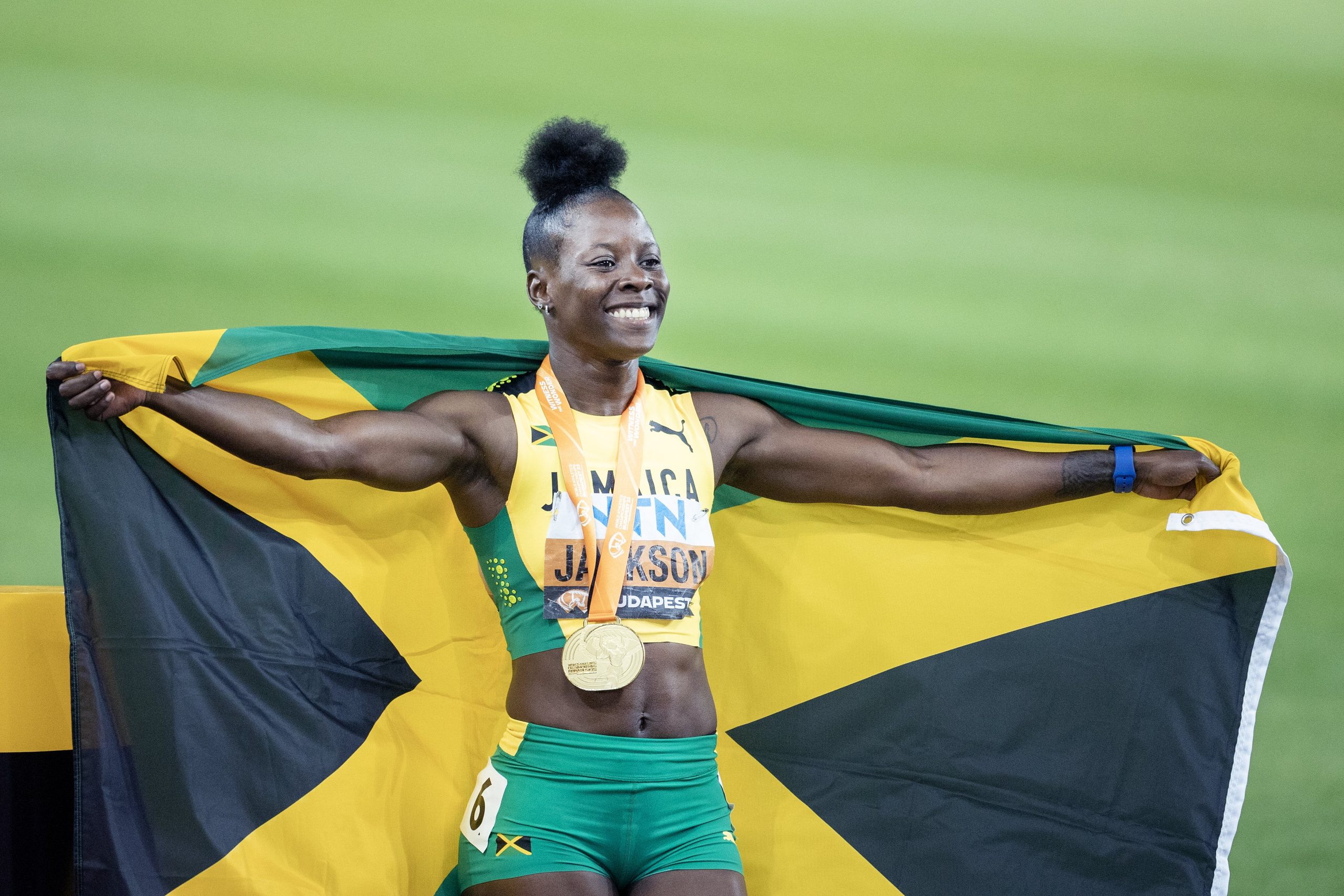 Shericka Jackson shows off a gold medal