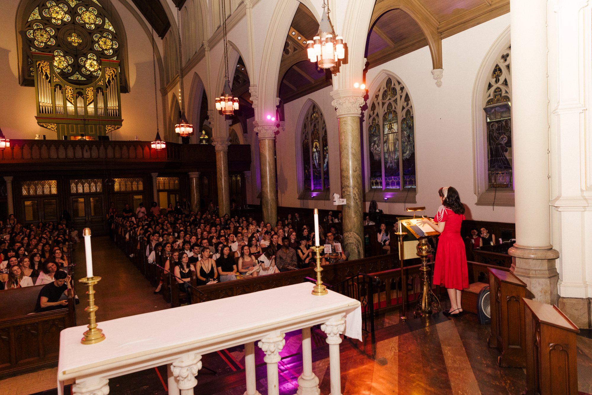 Rayne Fisher-Quann reads in front of a packed church.