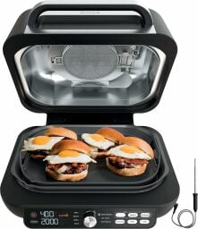 Ninja indoor grill with lid open and four chicken sandwiches on griddle