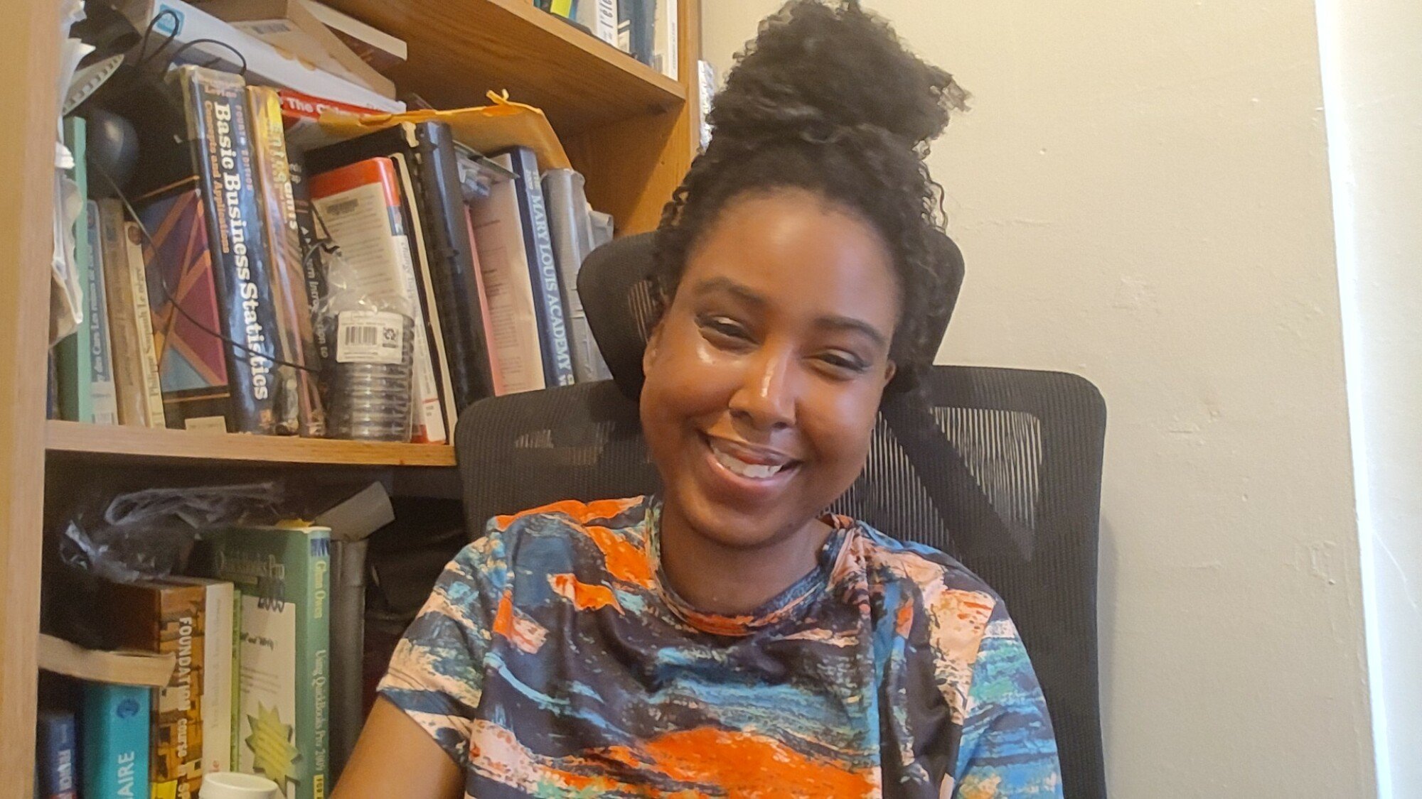 A woman sitting in an office in a Surface Laptop 7 selfie