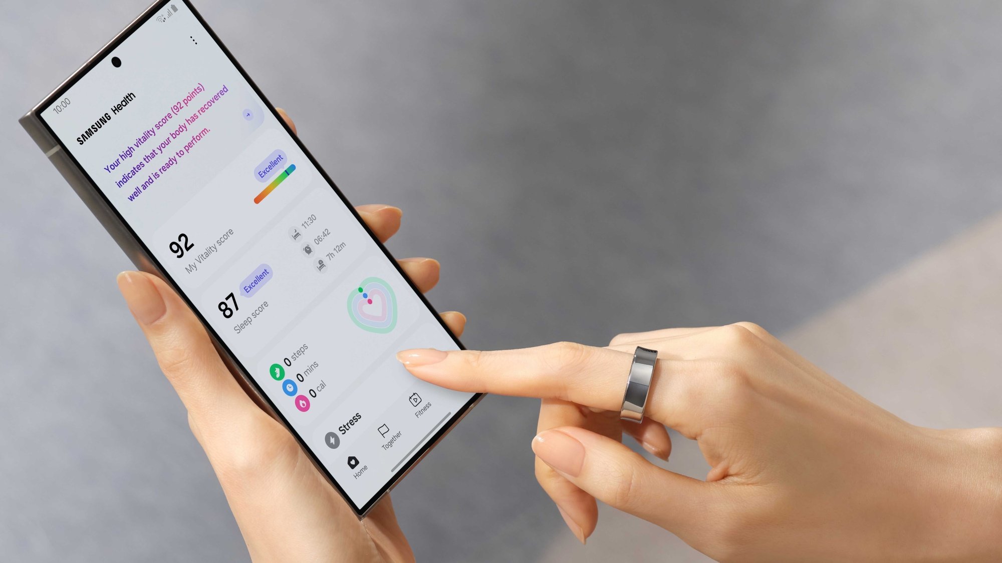 Woman wearing Samsung Galaxy Ring while using Samsung Health app on phone