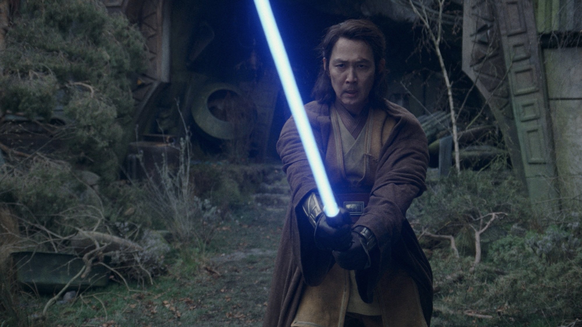 Jedi Master Sol wields his blue lightsaber in the ruins of the witch coven on Brendok.