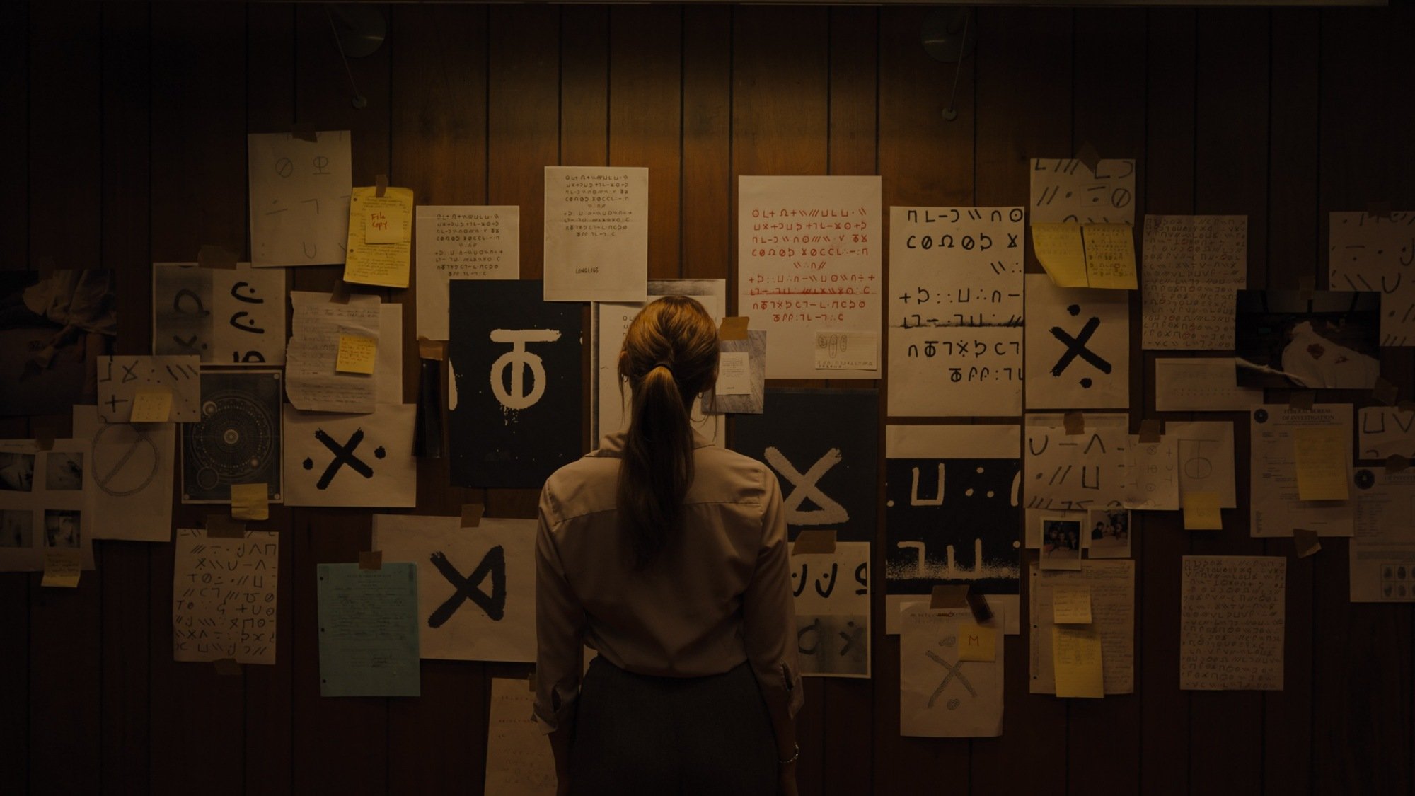 Maika Monroe looks at a wall of clues in "Longlegs."