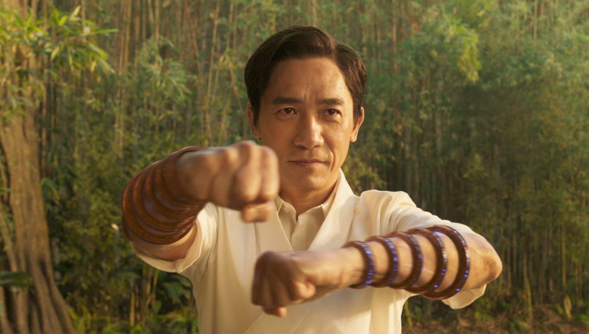 Wenwu (Tony Leung) in the middle of martial arts combat. He wears ten thick bracelets on his forearms, which are the magical Ten Rings.