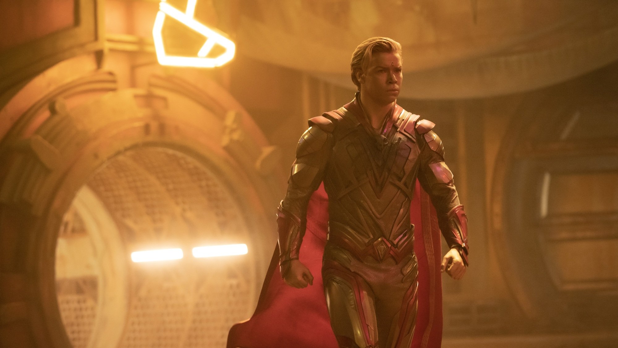 Adam Warlock, a man with shiny gold skin and a diamond on his forehead, wearing a suit of space armor with a red cape.