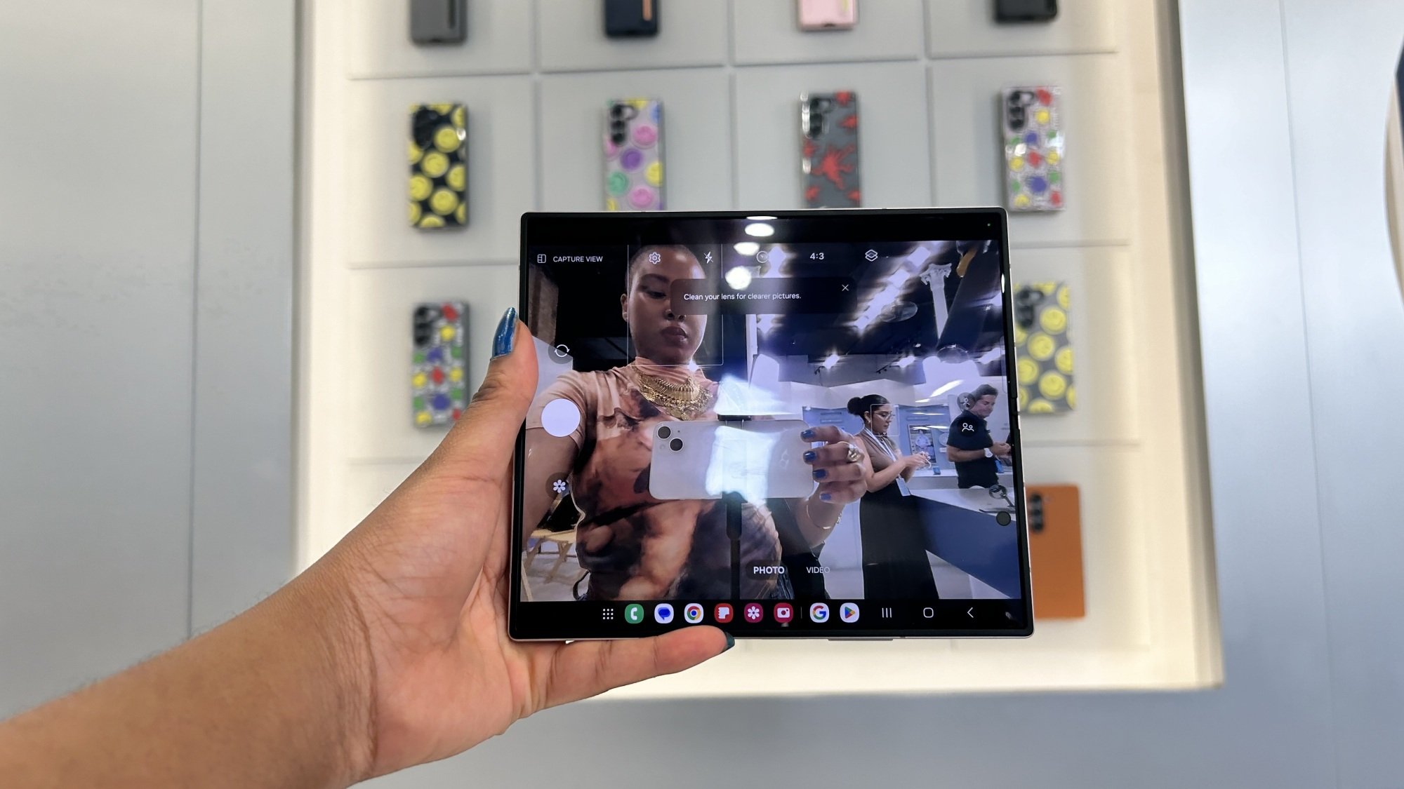 Hand holding Samsung Galaxy Z Fold 6 showcasing camera on inner display