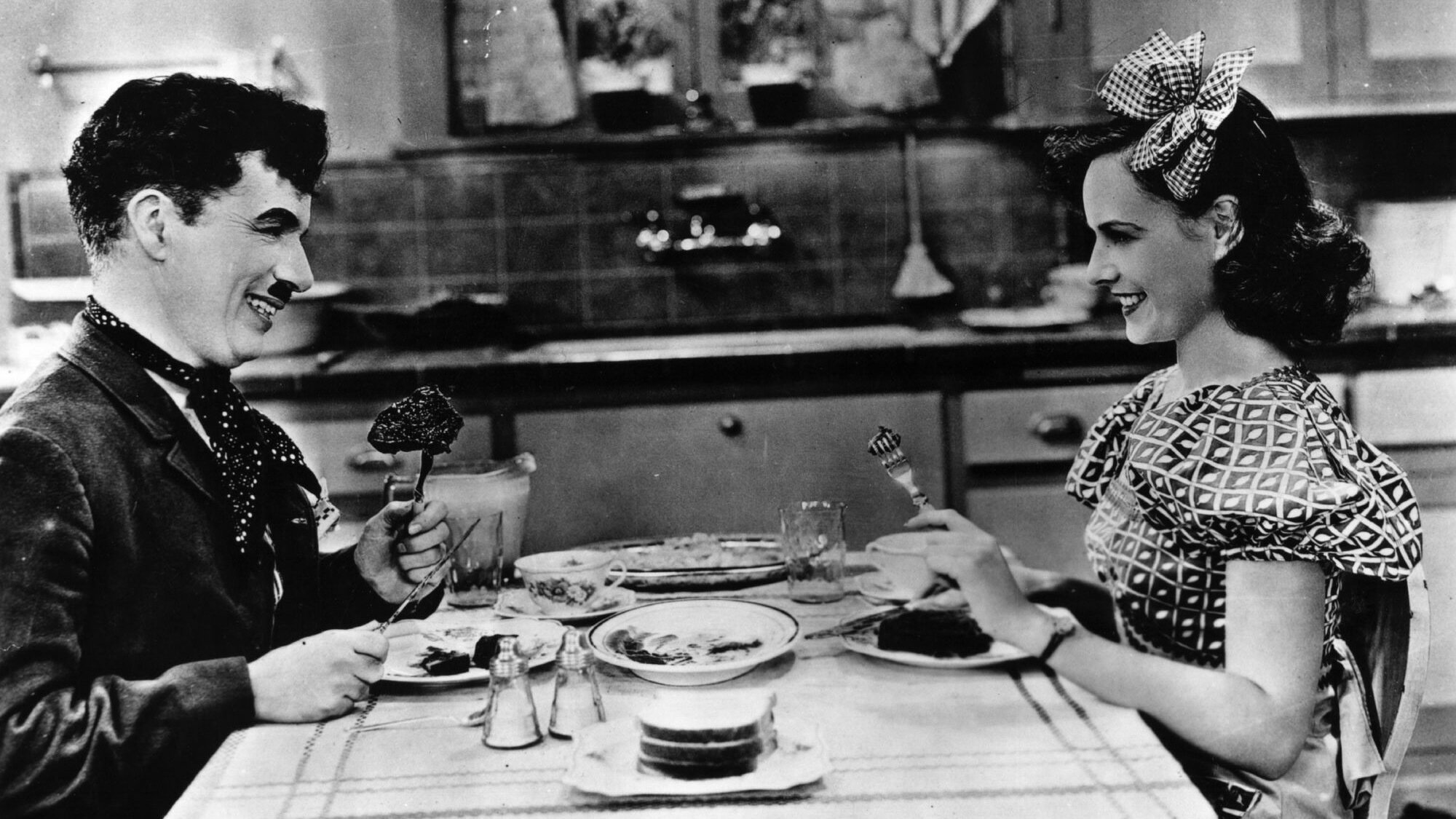 Charlie Chaplin smiles in a dinner scene in "Modern Times."