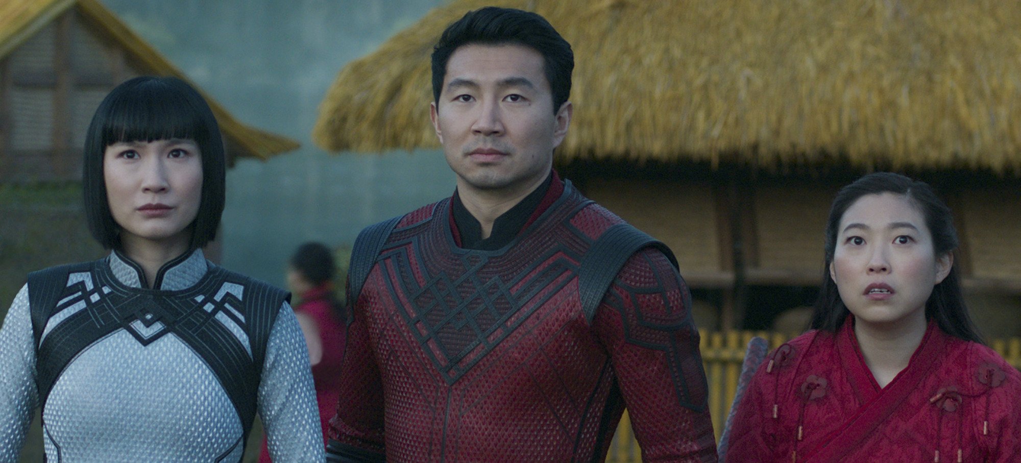 A close up of Shang-Chi (Simu Liu) flanked by his sister and best friend (Meng'er Zhang and Awkwafina), all dressed for battle.