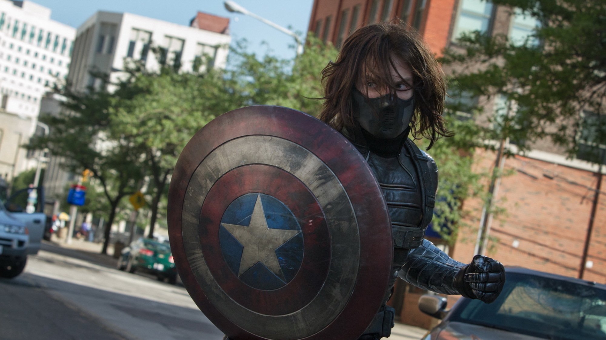 Bucky Barnes (Sebastian Stan) as the winter soldier; masked, armed, and holding Captain America's shield to use against him as a weapon.