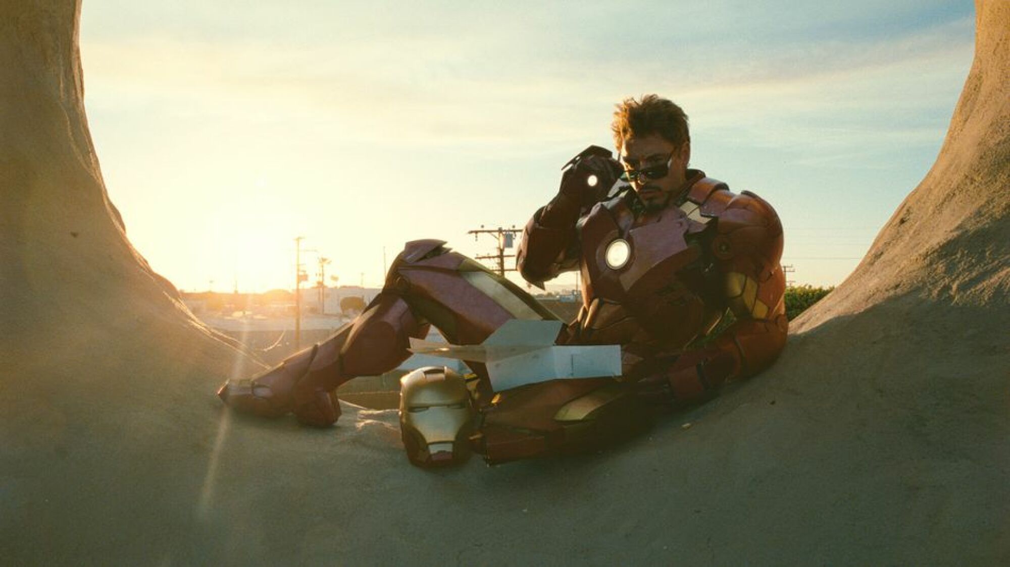 Robert Downey Jr. as Iron Man, metal suit and all, reclining with some doughnuts.