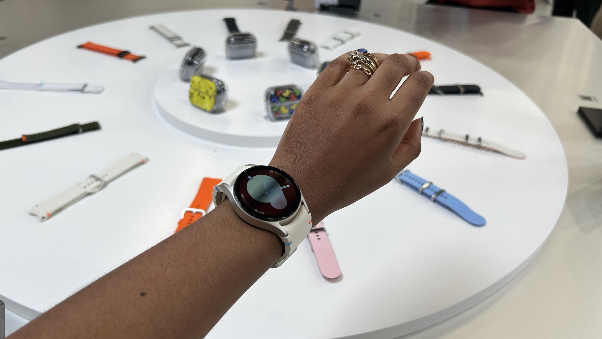 Woman wearing Galaxy Watch 7 with straps in the background