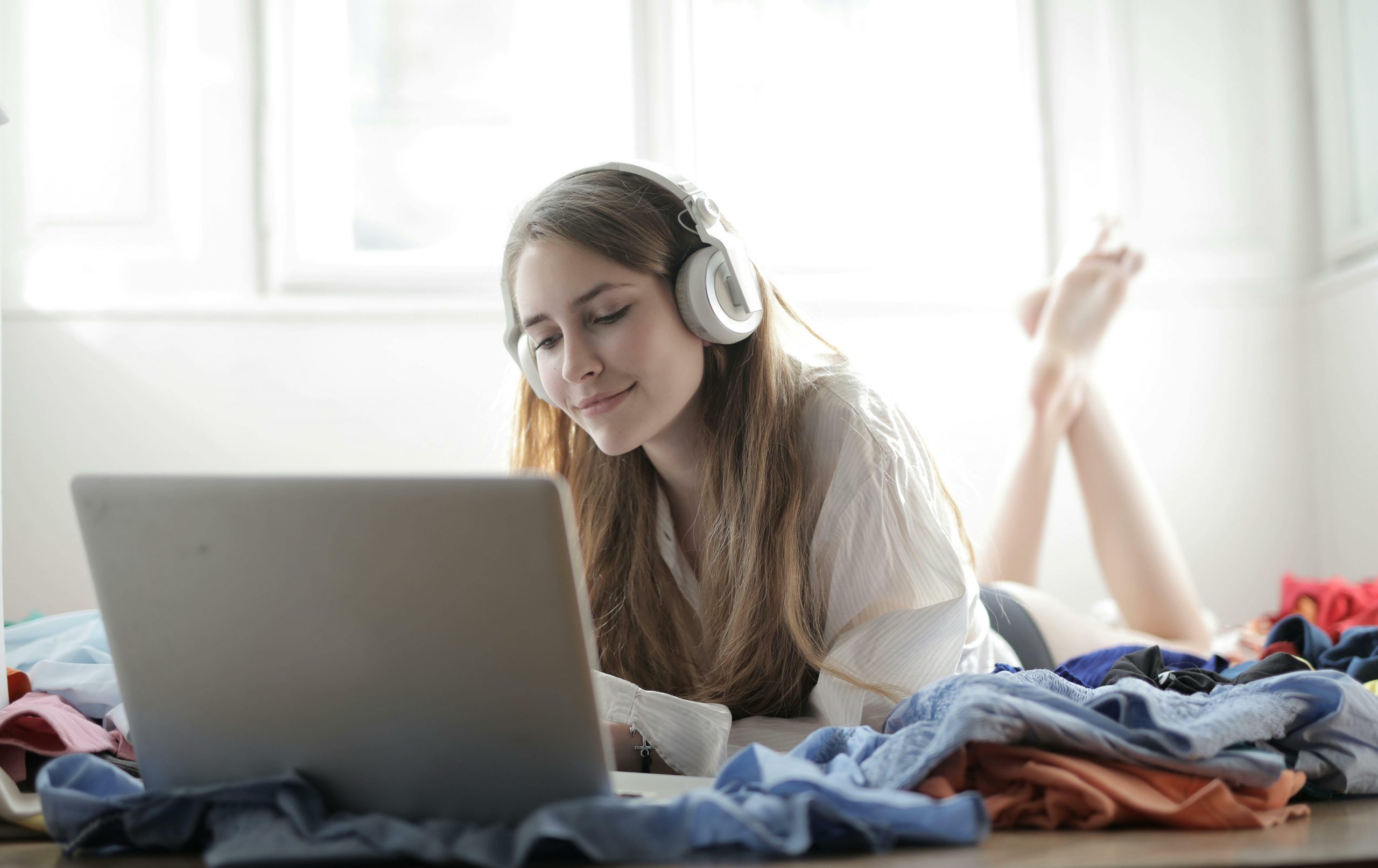 young woman streaming on laptop with headphones