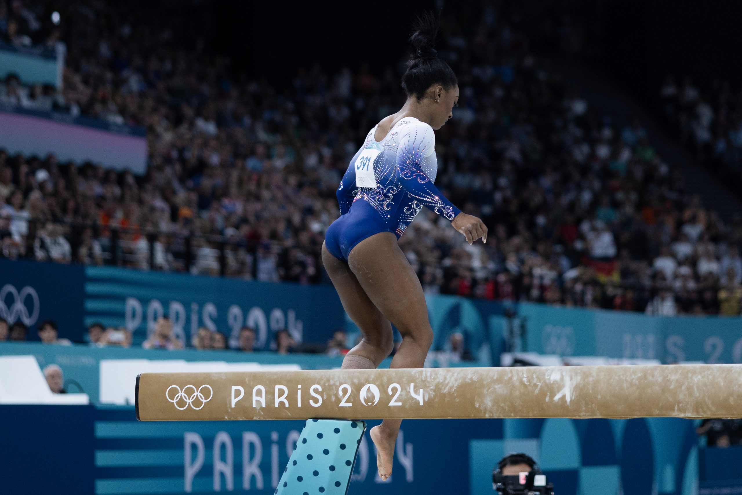 Simone Biles hops down from the balance beam. 