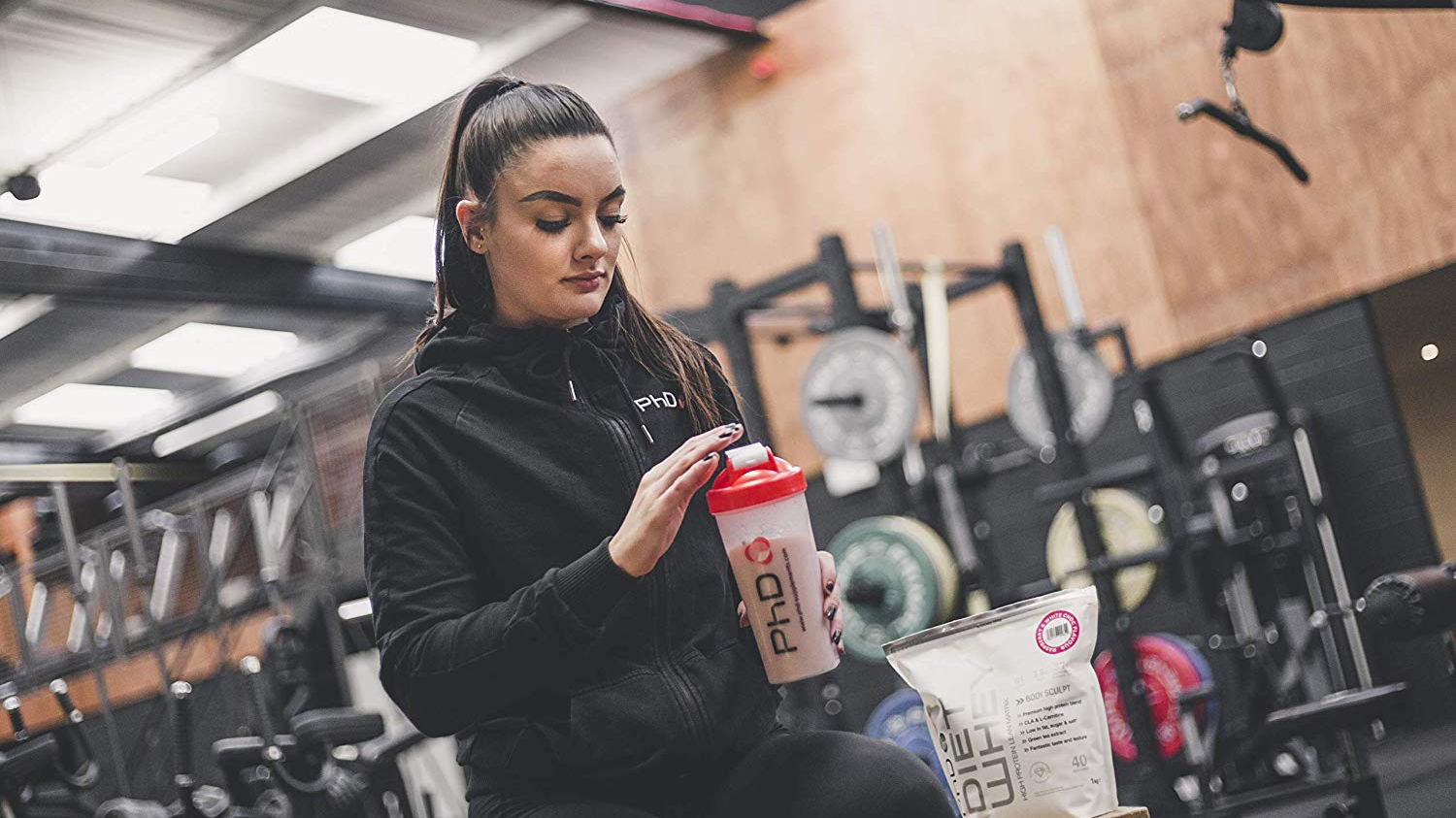 woman in gym with a protein shake