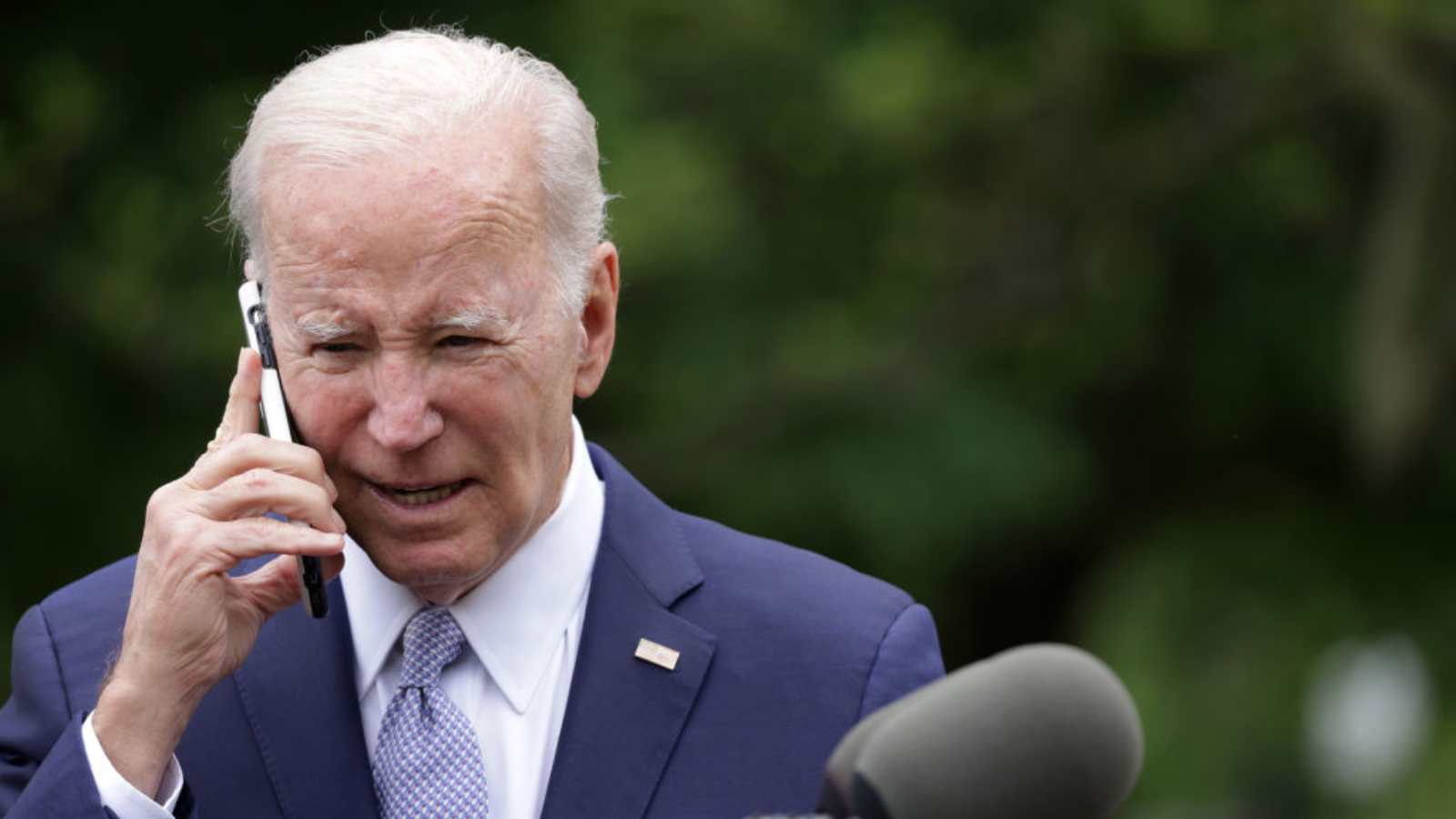 U.S. President Joe Biden talks on a cell phone during a Rose Garden event at the White House to mark National Small Business Week on May 1, 2023 in Washington, DC.