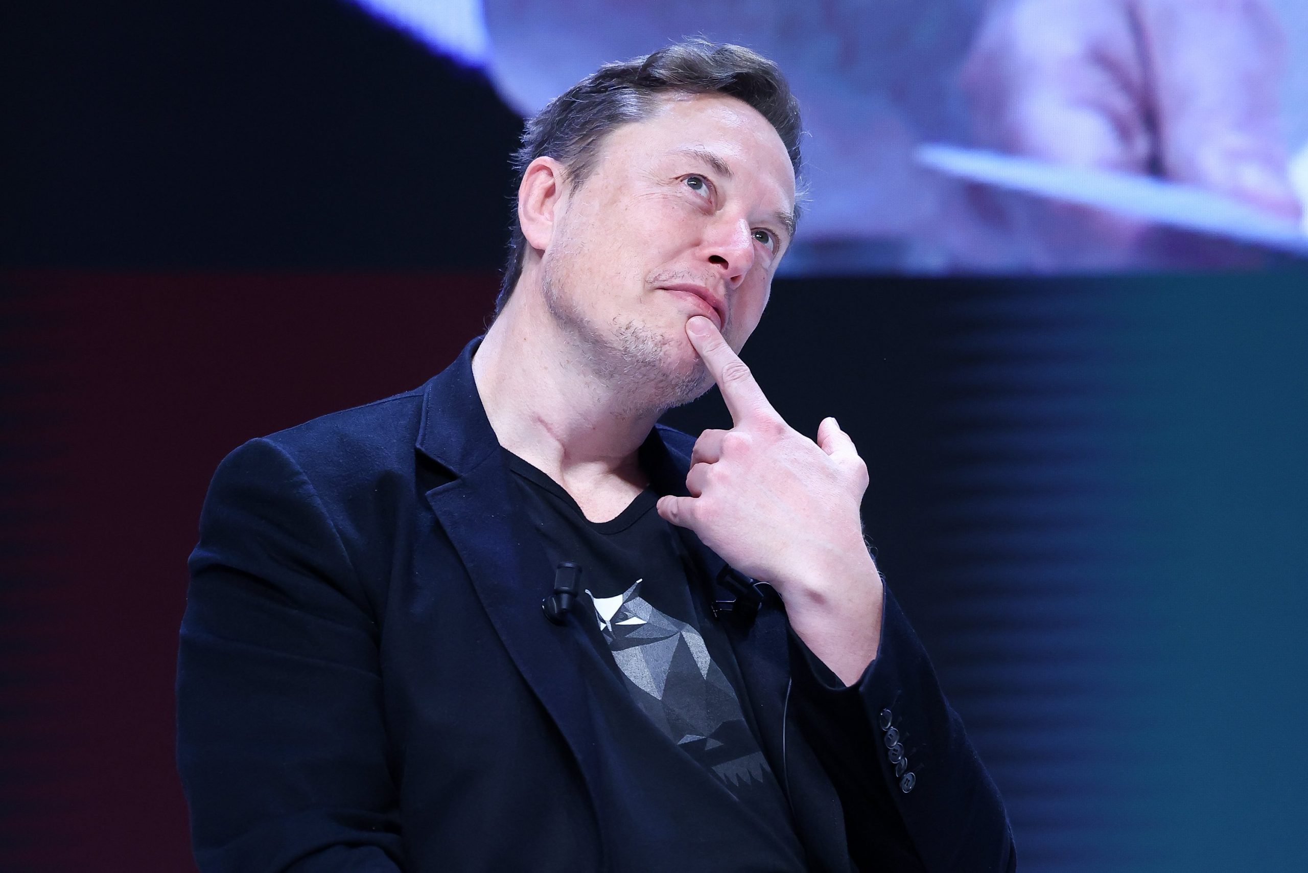 elon musk posing with a finger under his chin