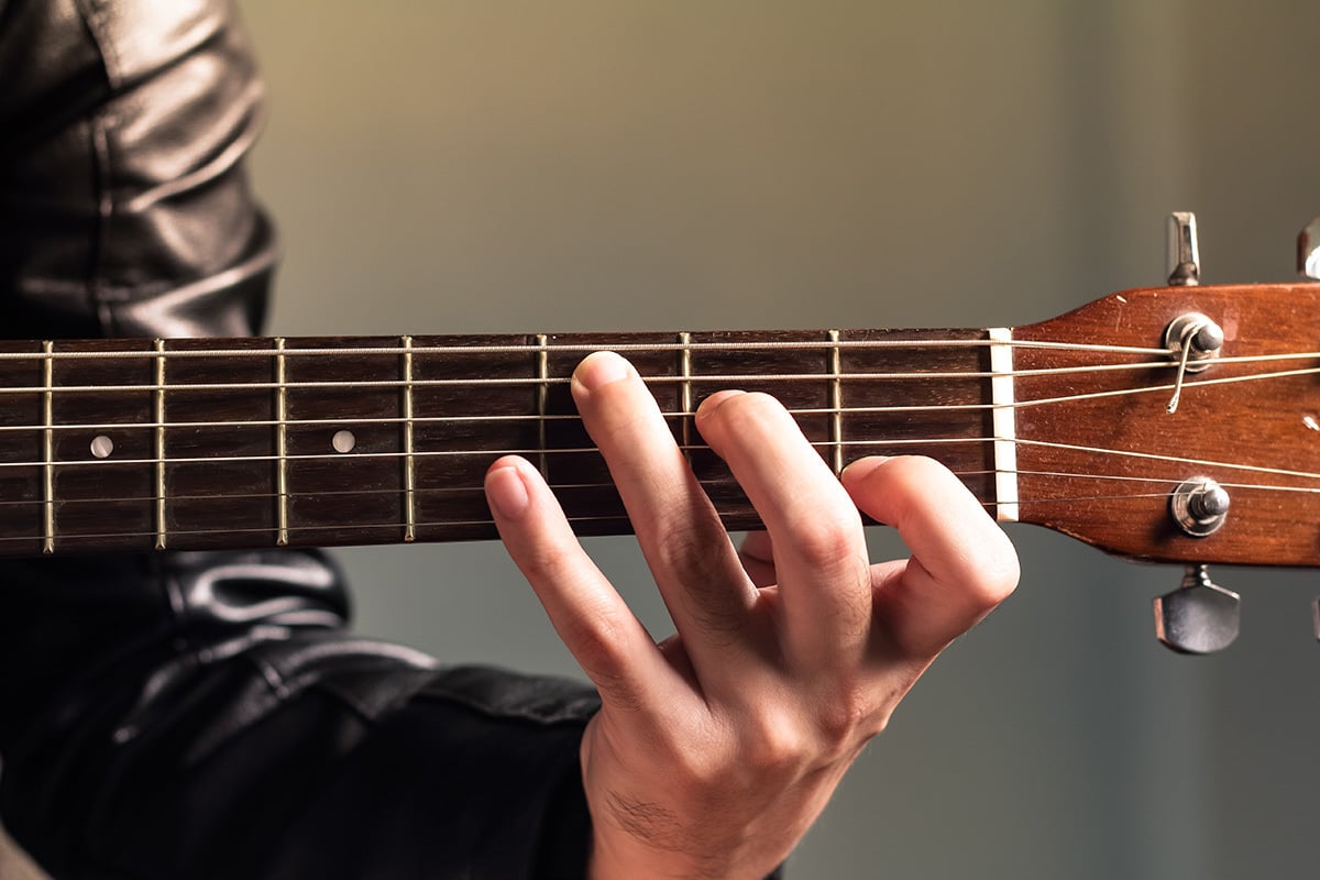 close-up of person playing guitar