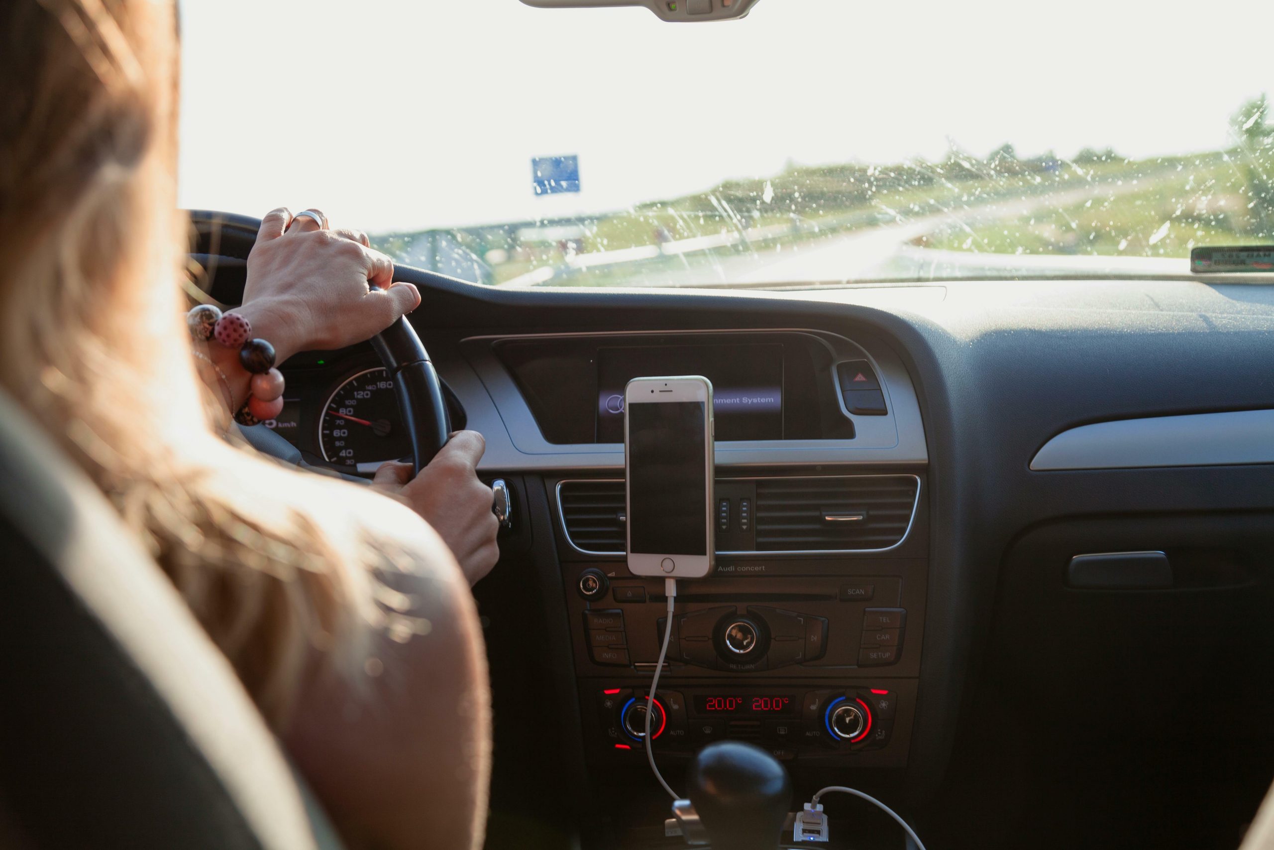 woman driving car with phone in hands-free position