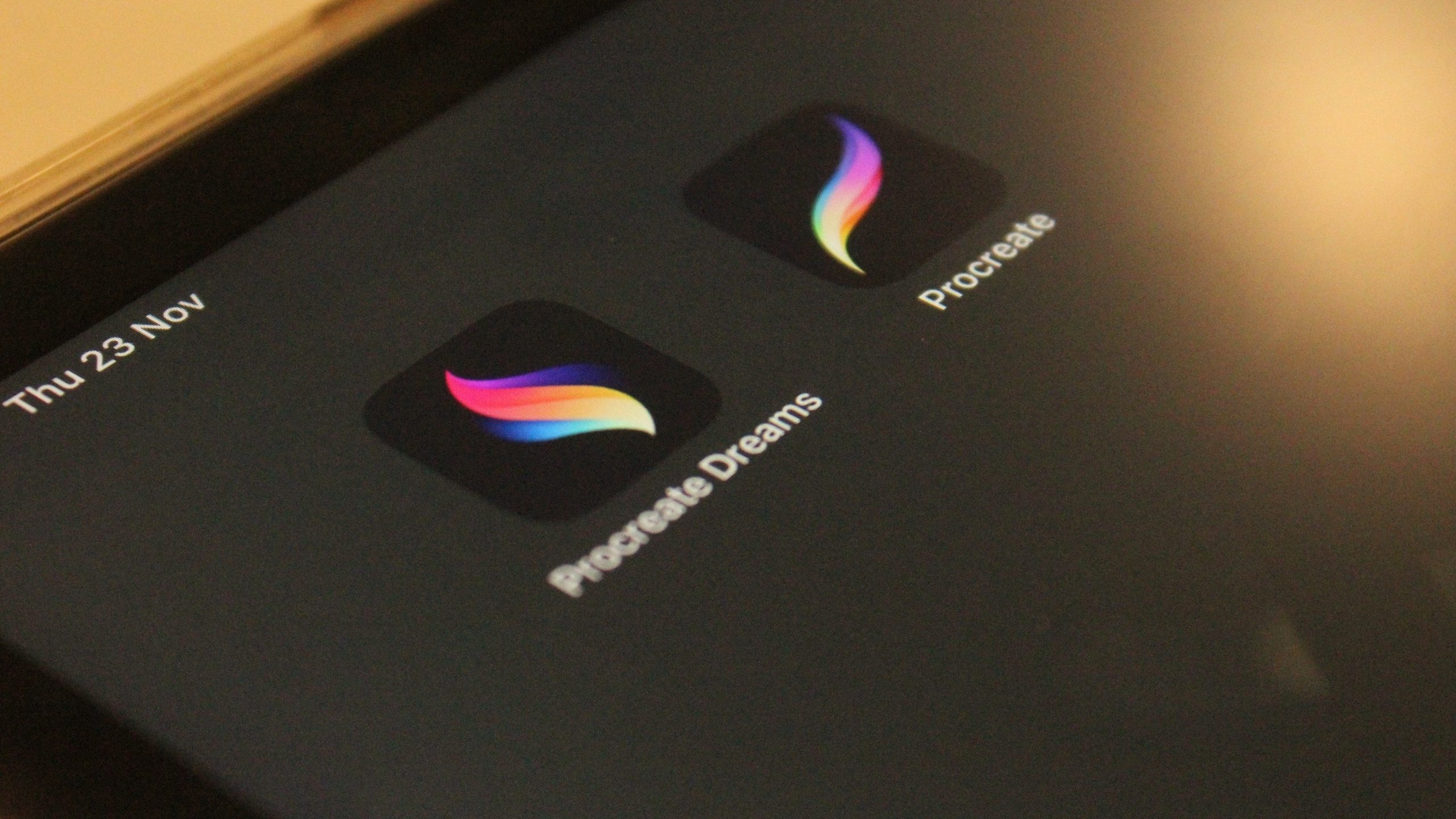 A close-up view of the Procreate app logo beside the Procreate Dreams app displayed on a tablet screen