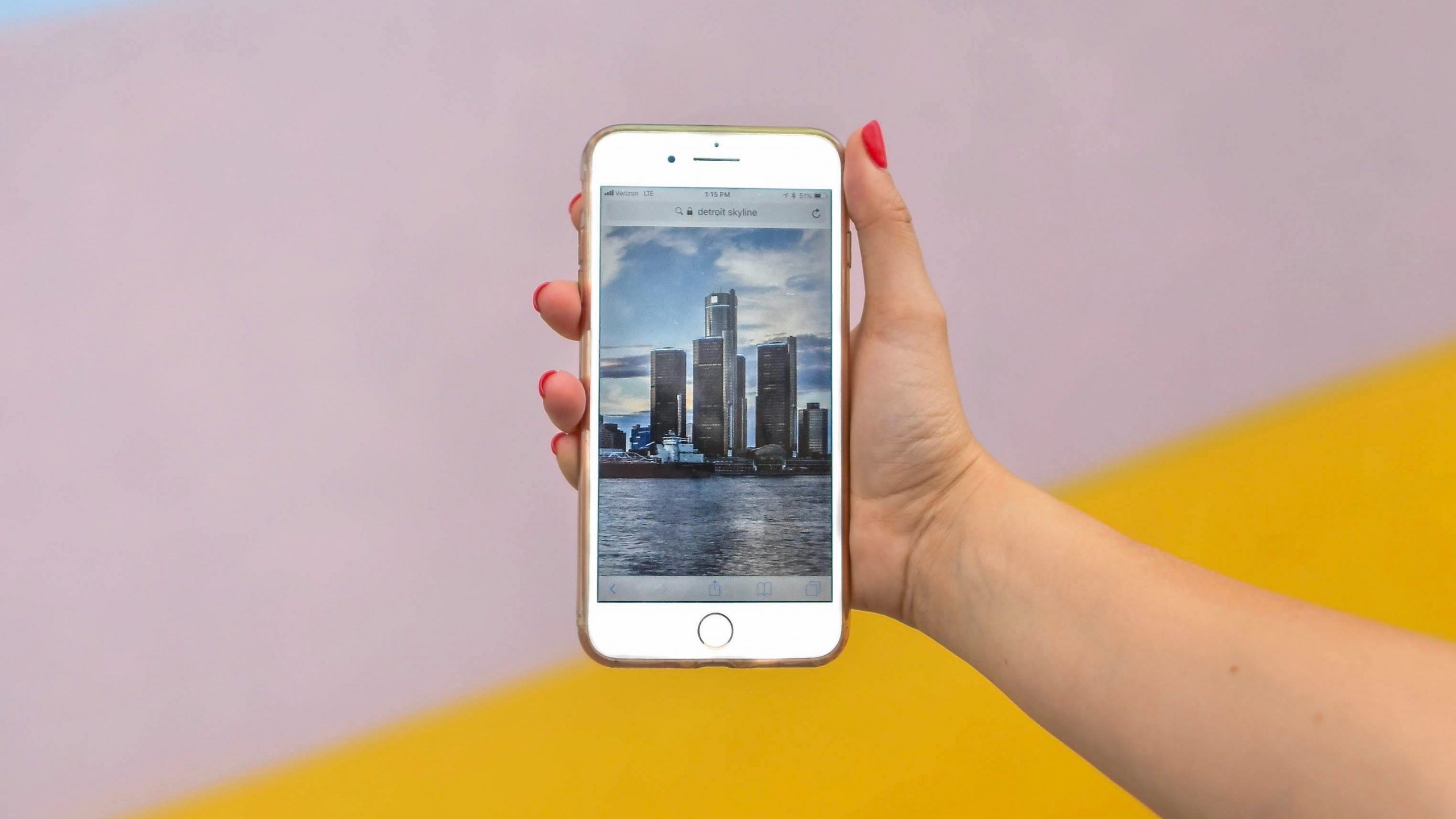 woman holding up phone with picture of city skyline on screen