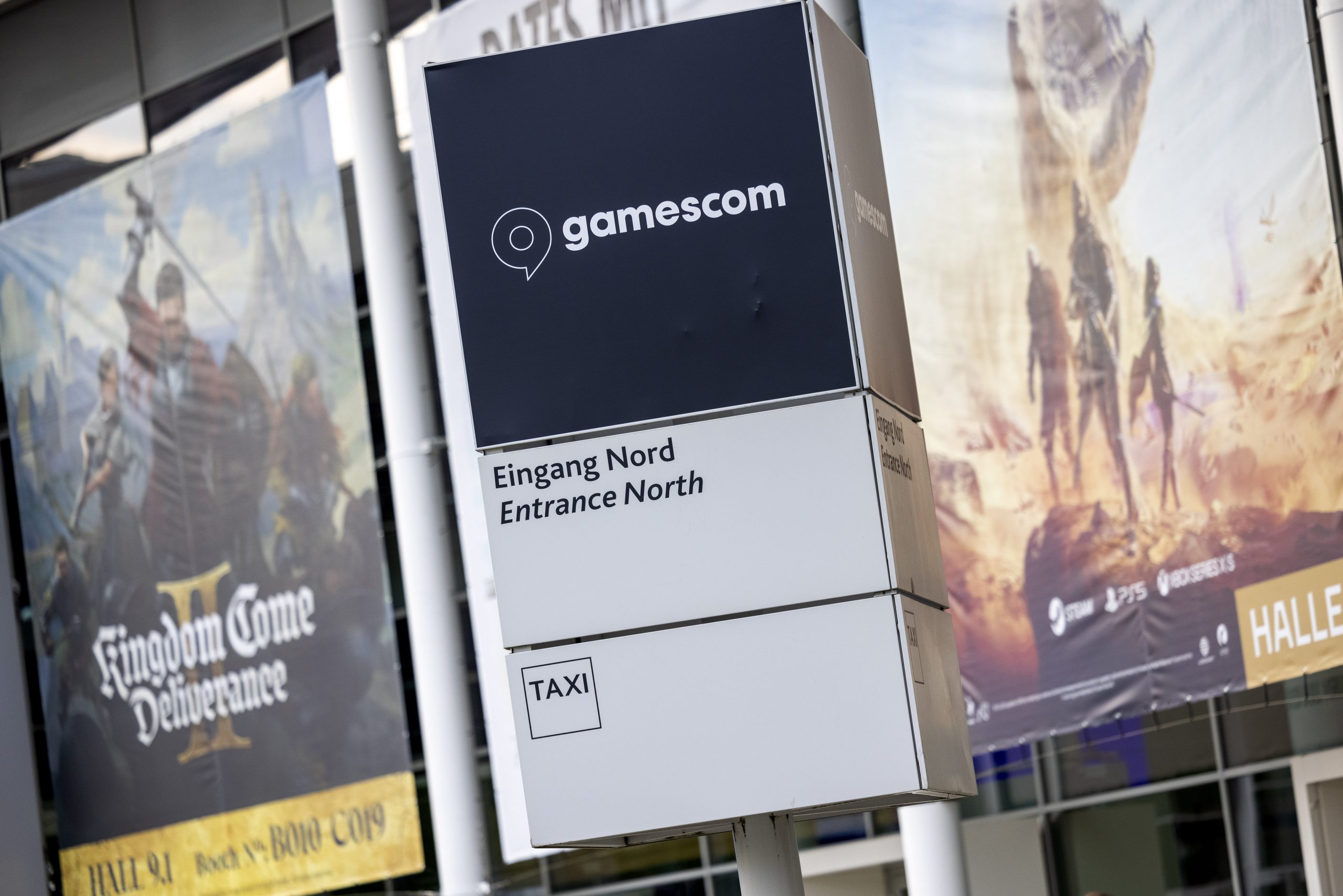 Oversized posters advertise computer games in front of the entrance to the Gamescom games fair