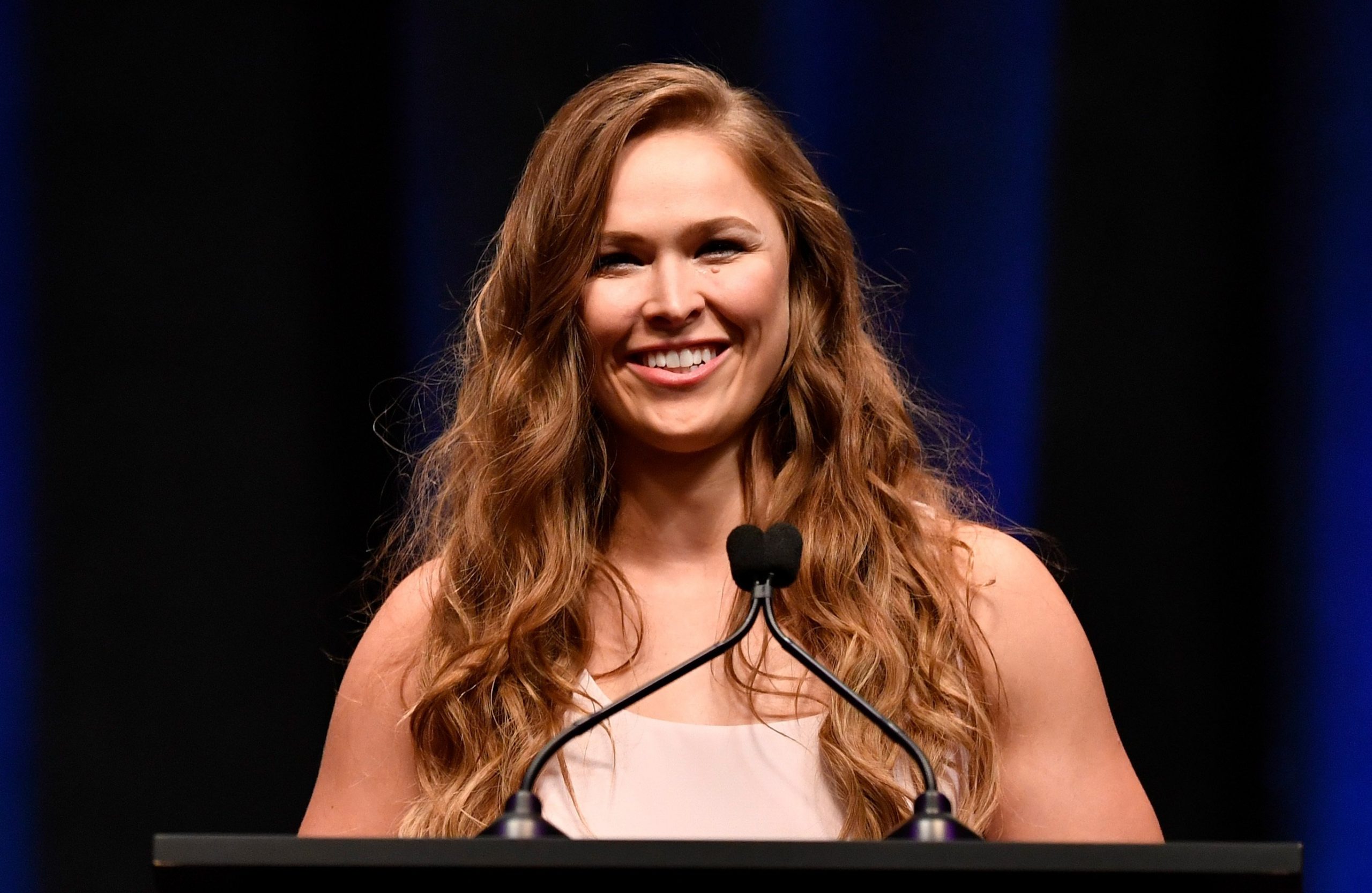 ronda rousey standing at a lectern