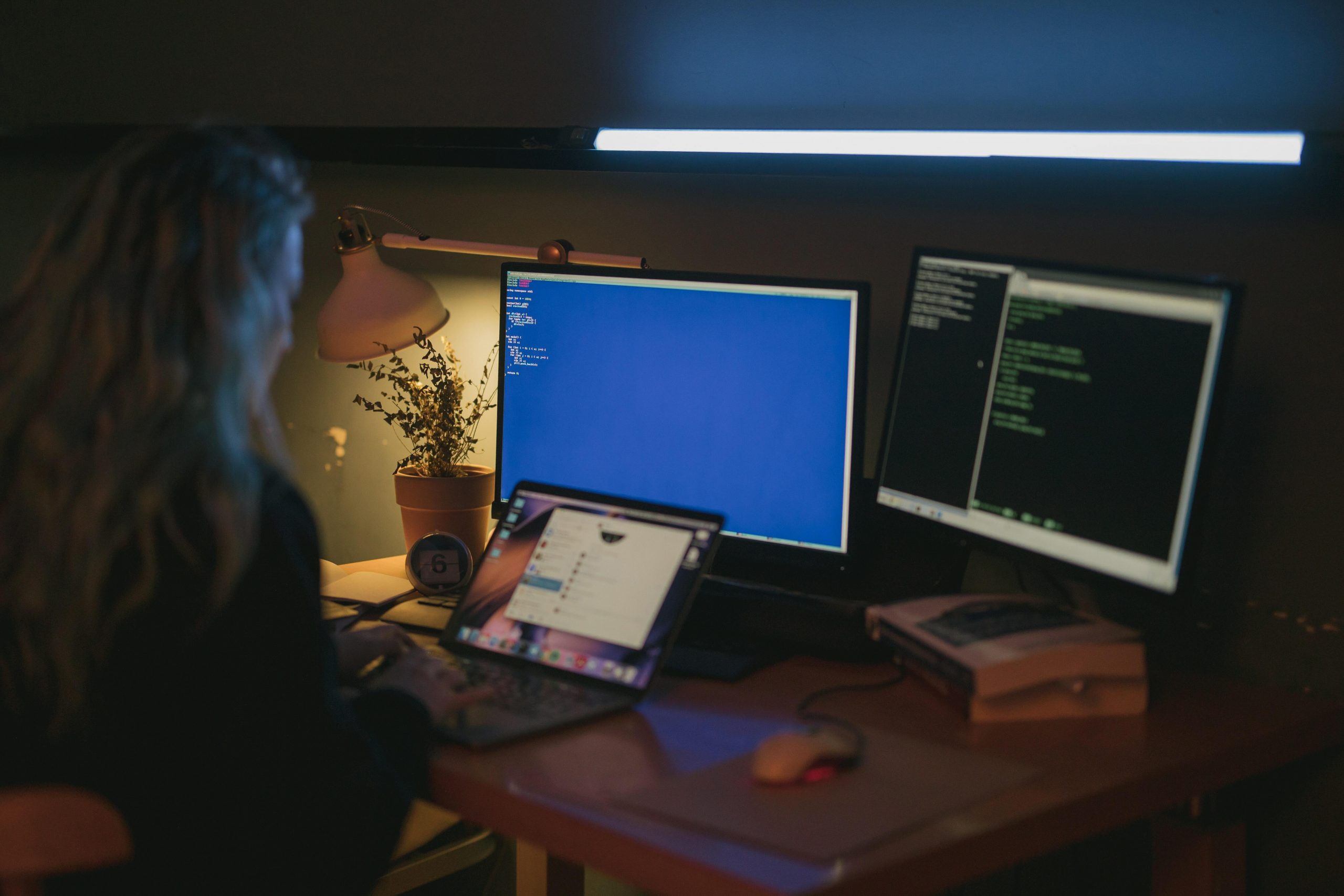 person working on desktop in dark office