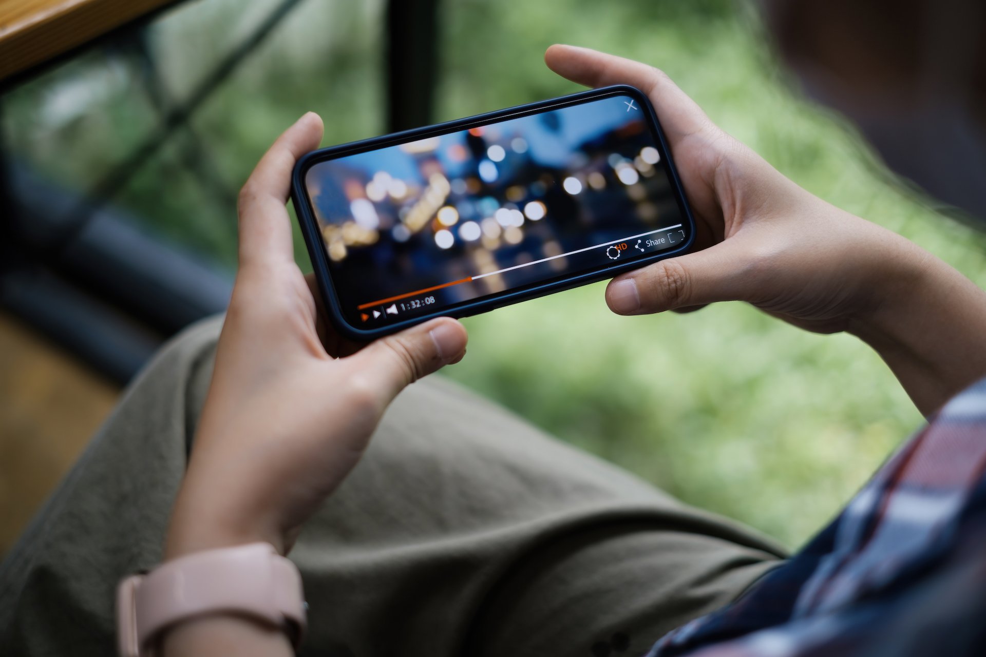 Person holding a phone with a video playing.