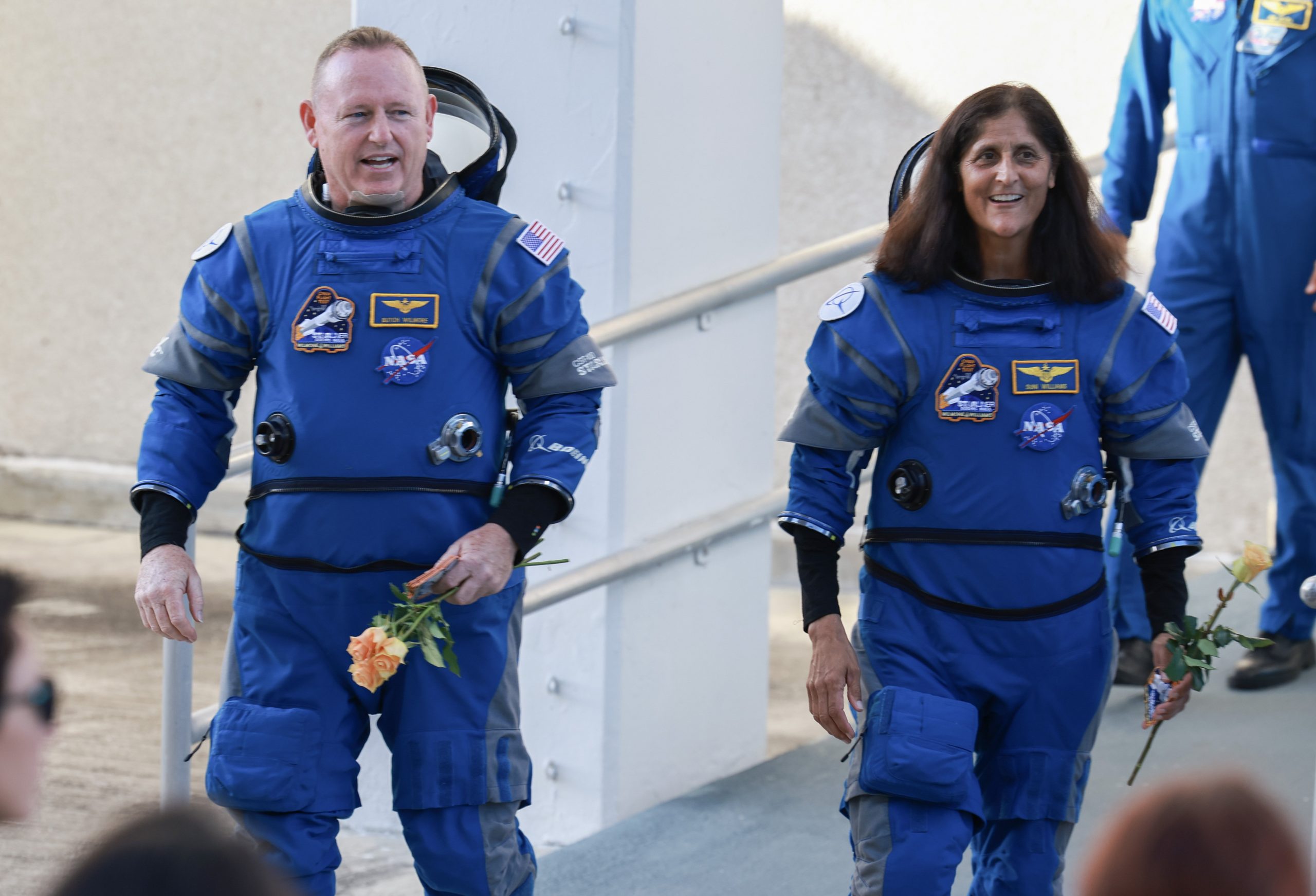 Butch Wilmore and Suni Williams walking in astronaut suits