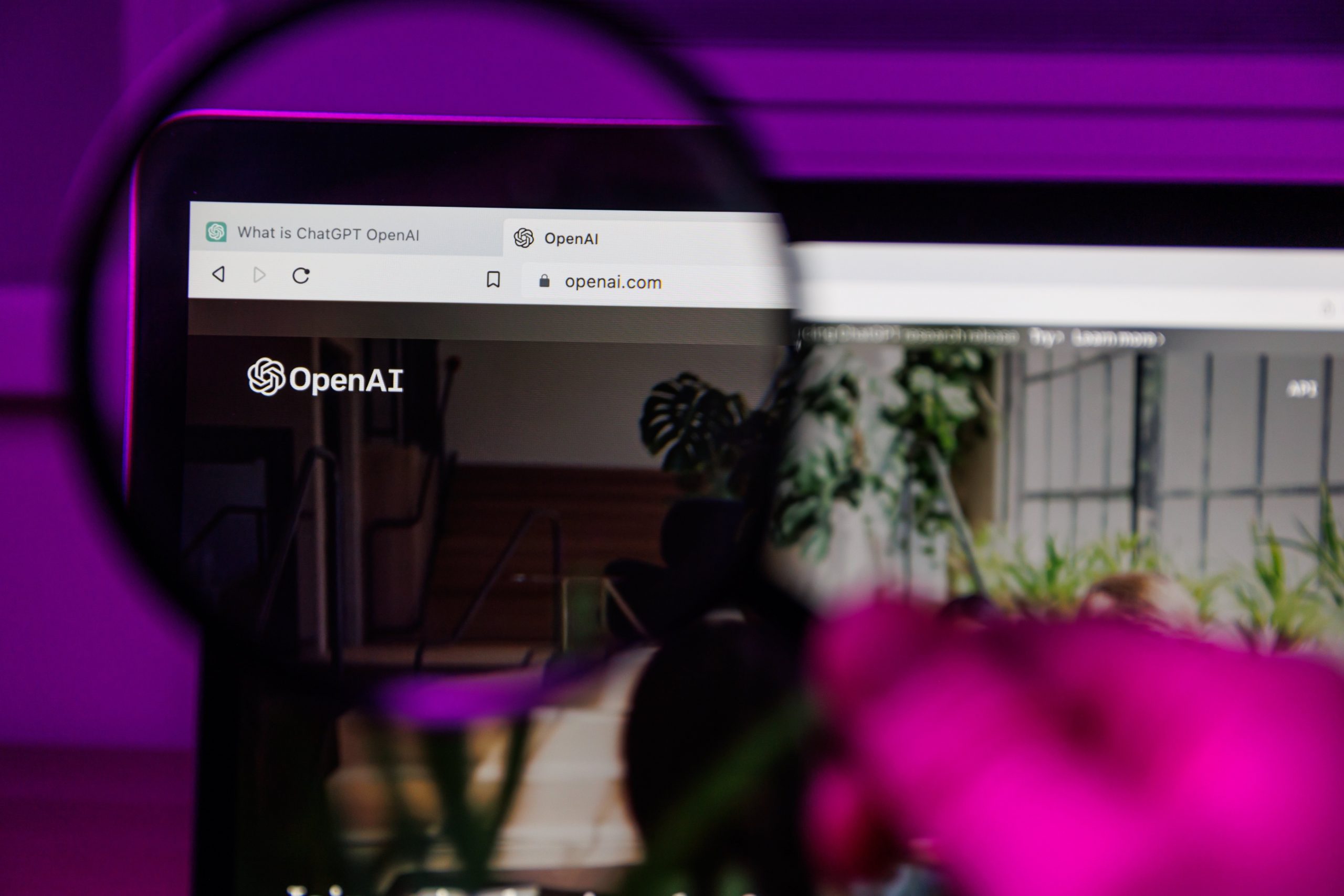 ChatGPT OpenAI website through magnifying glass on screen