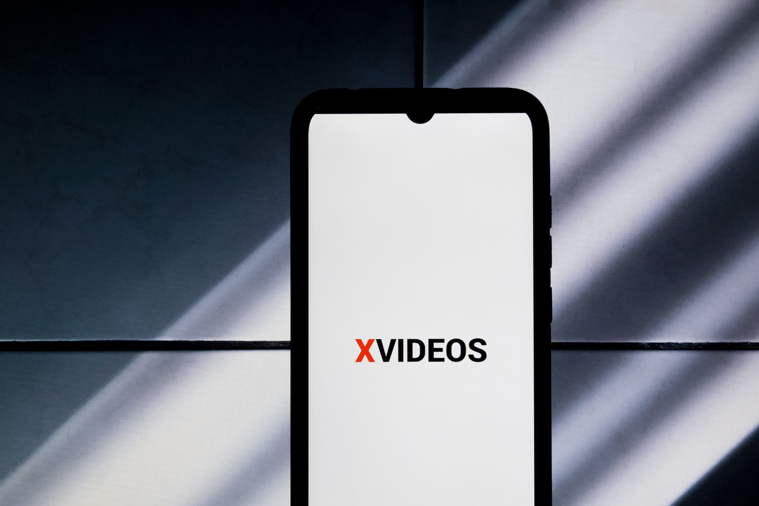 The XVideos logo is being displayed on a smartphone screen