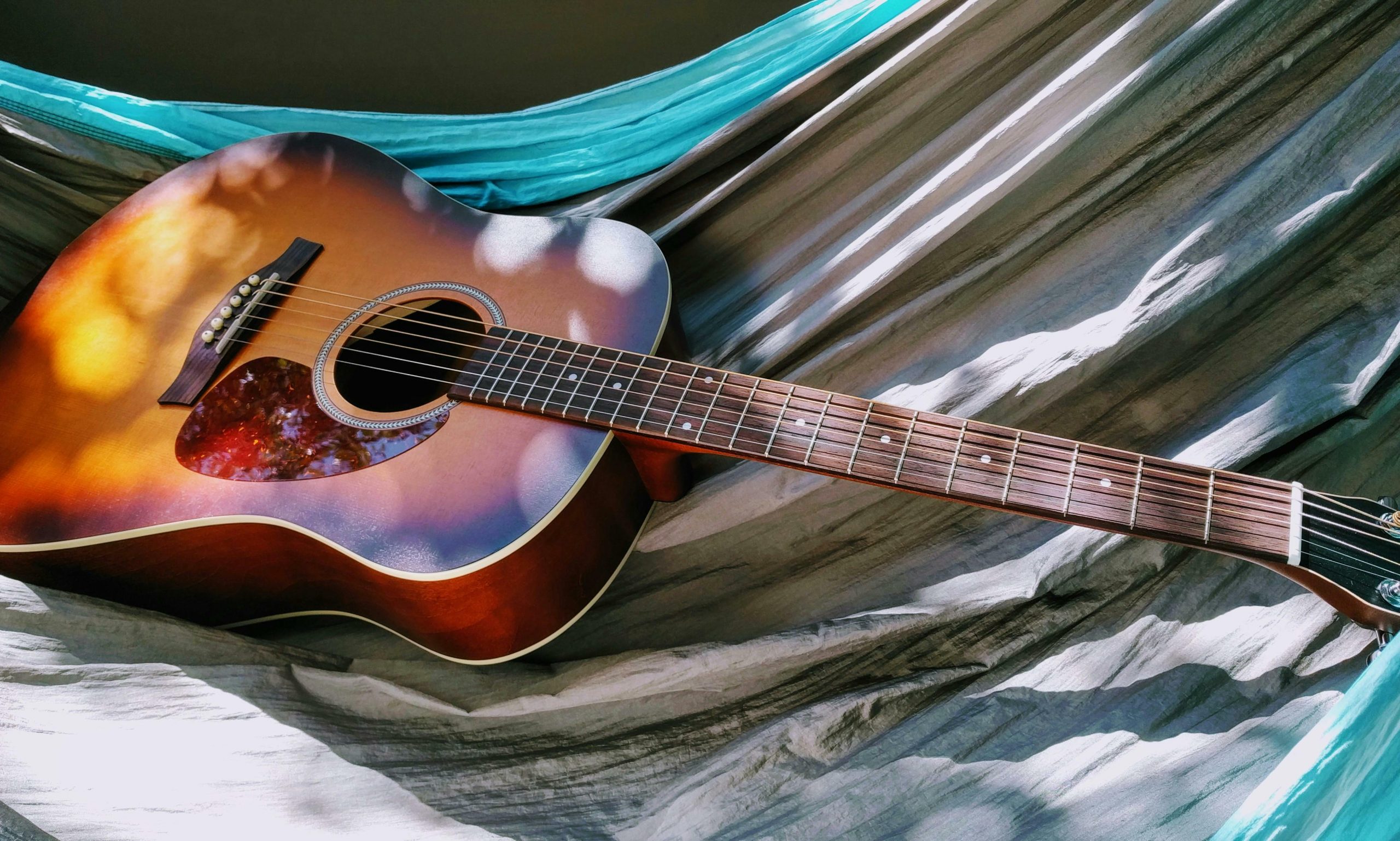 guitar in a sun beam on a hammock