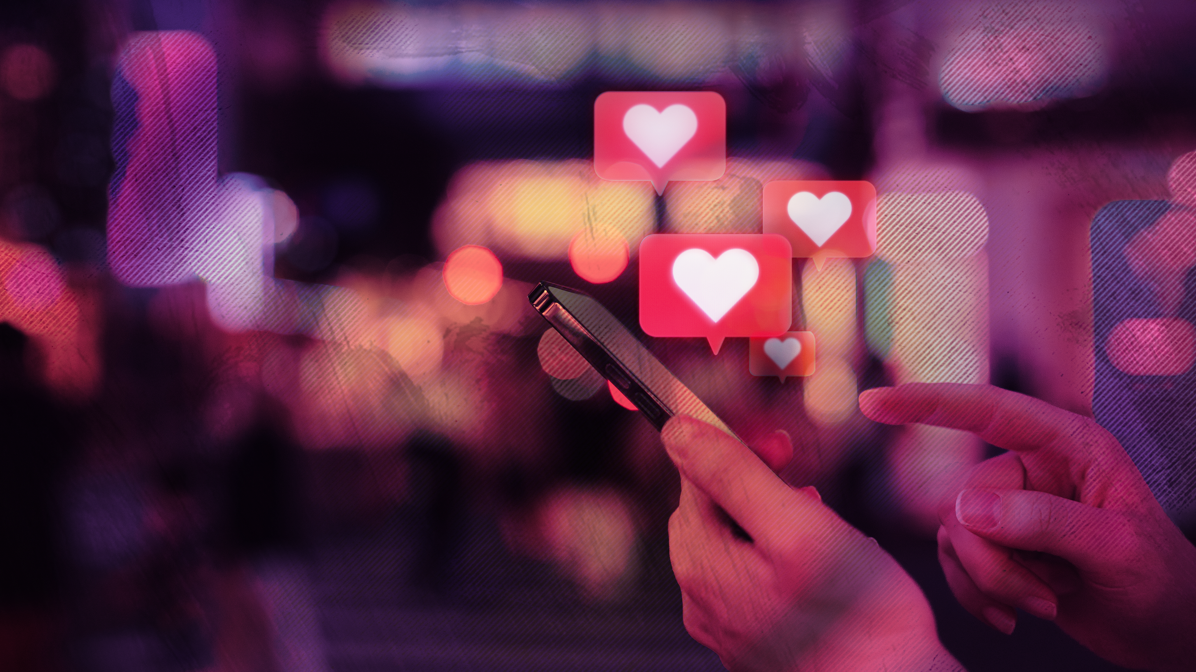 a hand holds a phone as heart emojis appear to float out to the screen