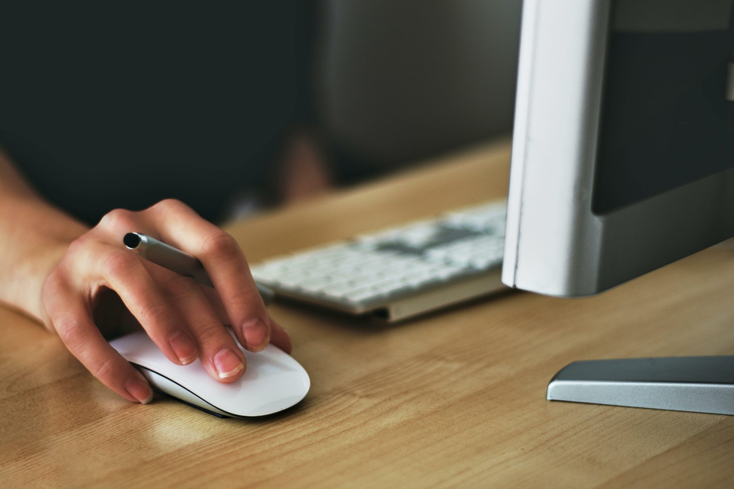 person holding Apple magic mouse