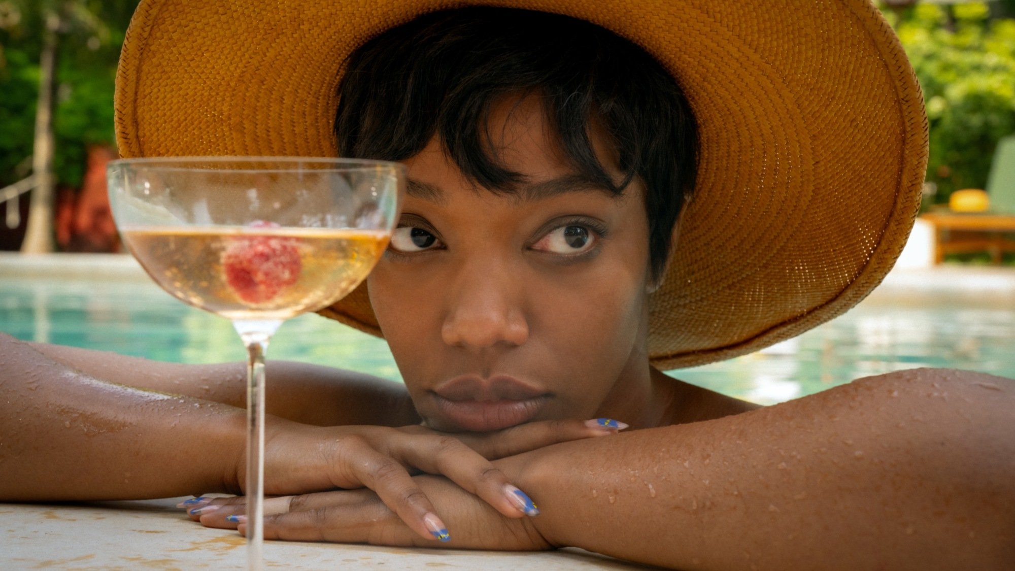 Frida (Naomie Ackie) chills in a pool in "Blink Twice."