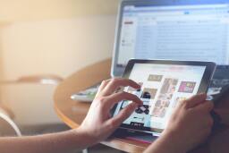 Person using a tablet in front of computer