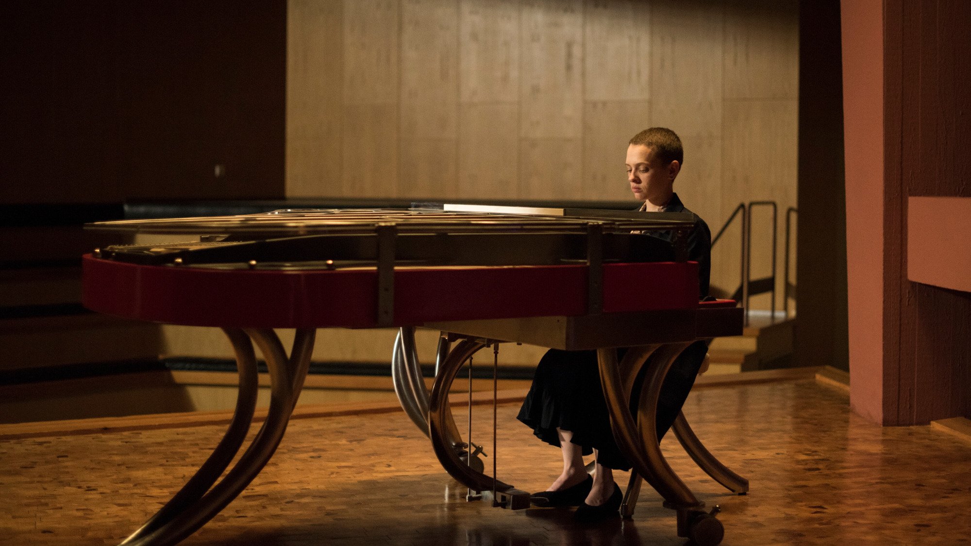 A woman plays the piano on stage. 