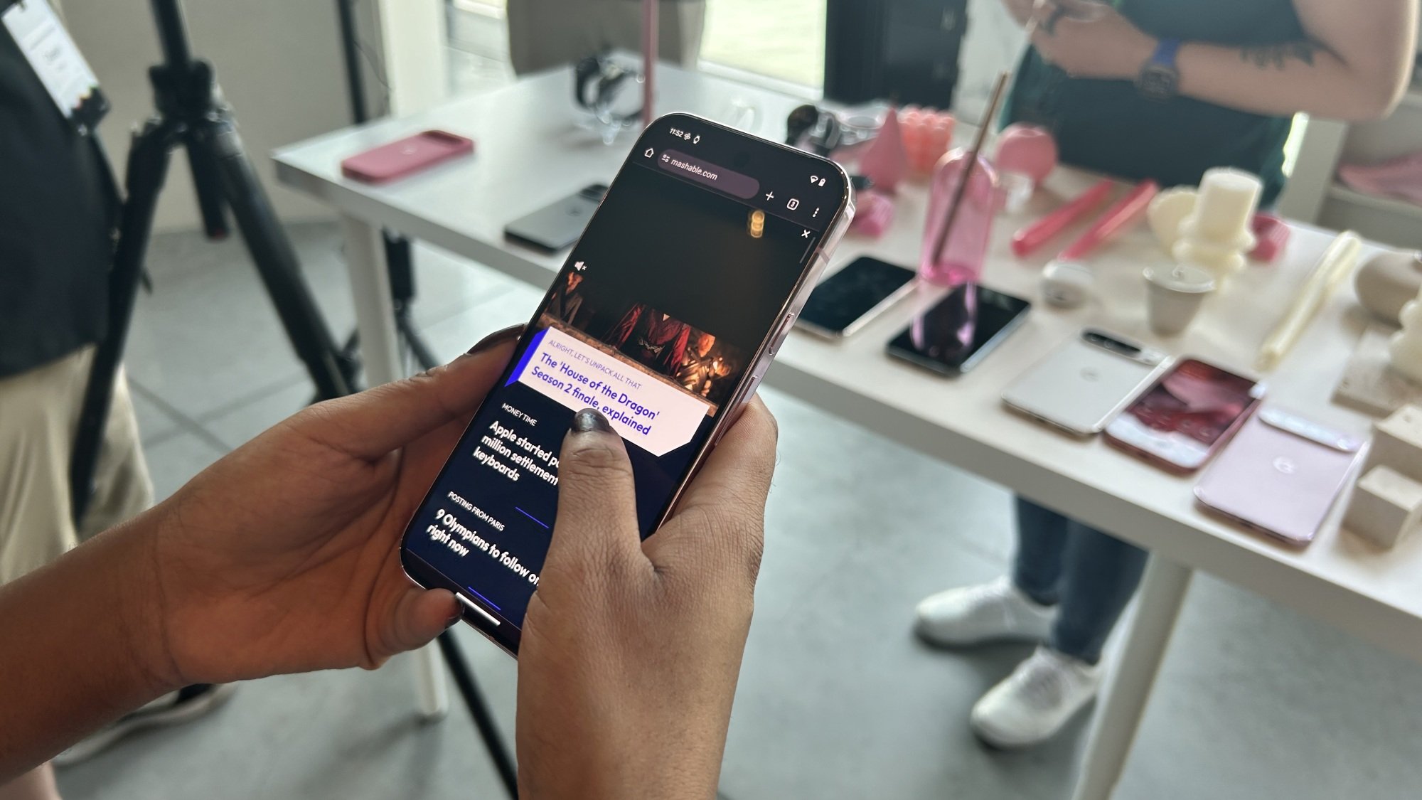 A woman holding a Pixel 9 Pro XL phone and scrolling through Mashable