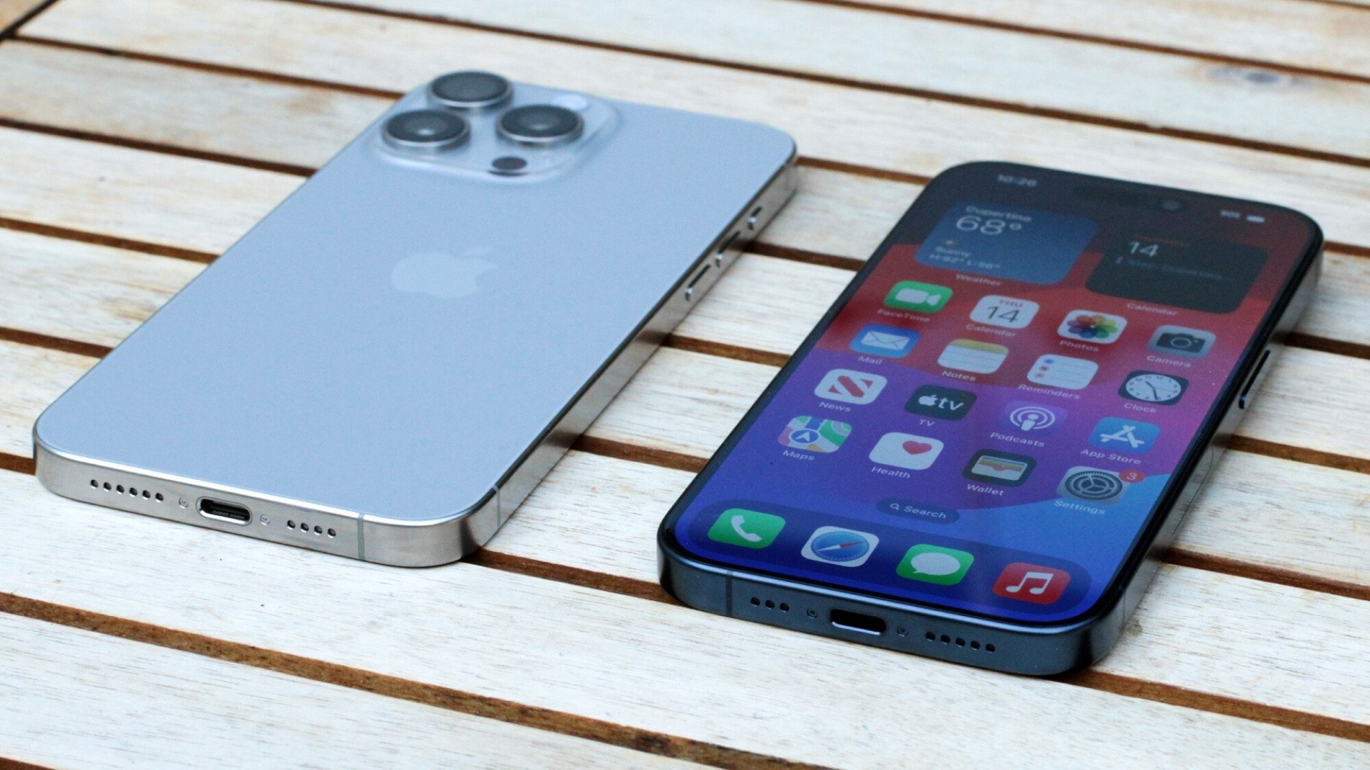 Two iPhones lying on a wooden platform