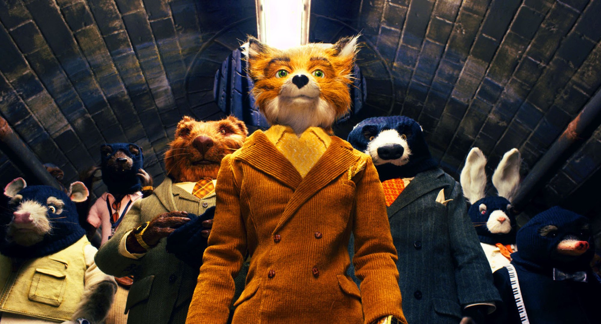 A fox puppet stands in front of an array of other animal puppets.