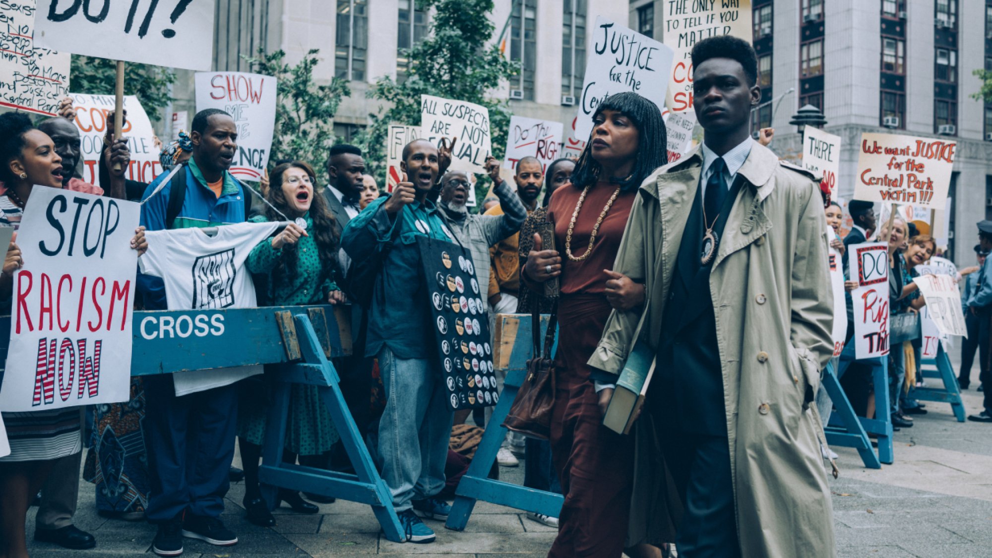 A mother and her son walk through a crowd of protestors. 