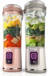 two ninja portable blenders beside one another full of unblended ingredients like fruit and ice cubes