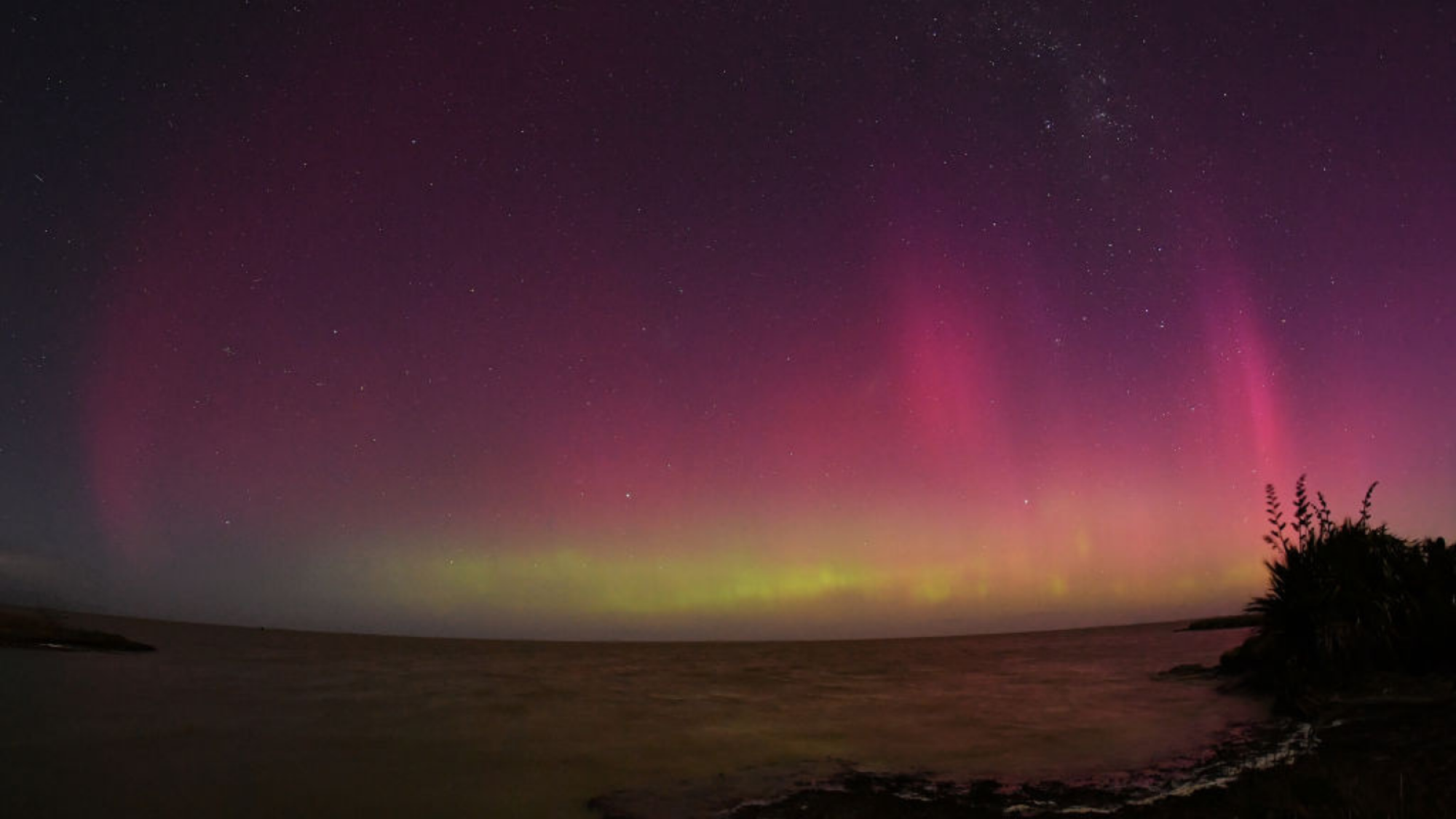 The Aurora Australis, also known as the Southern Lights, is glowing on the horizon over the waters of Lake Ellesmere on the outskirts of Christchurch, New Zealand, on August 12, 2024.