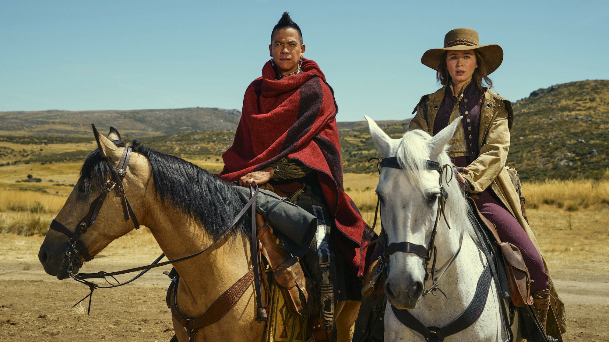 Chaske Spencer and Emily Blunt sit on horseback in the American West in the TV show "The English"