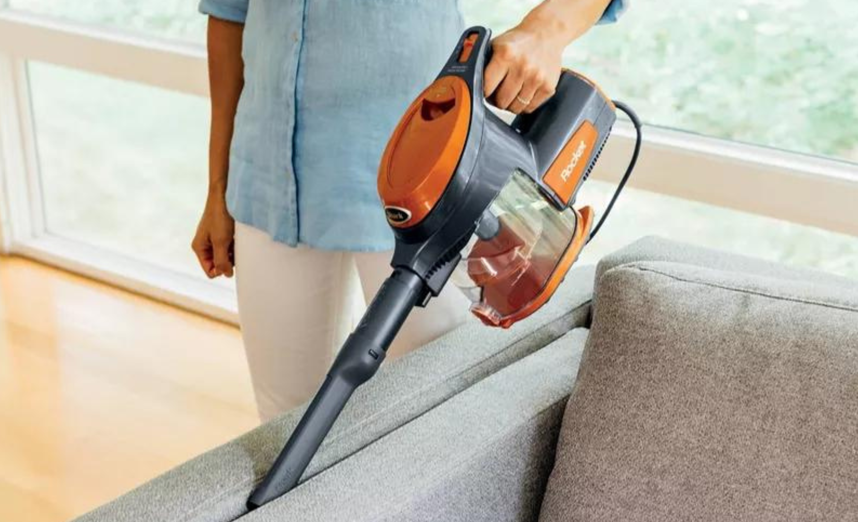 person vacuuming couch with Shark vacuum 