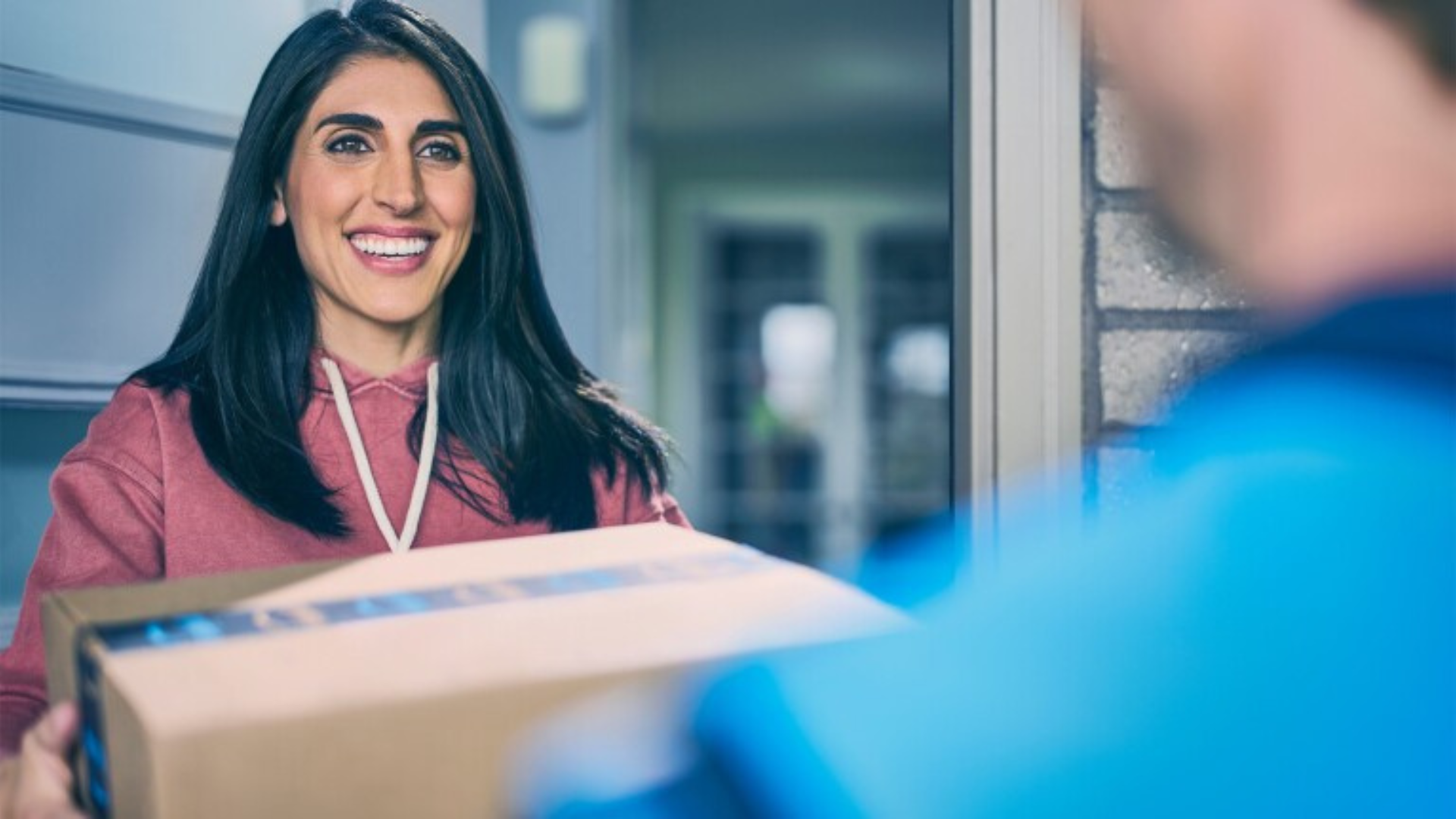 A person getting handed a box from Amazon